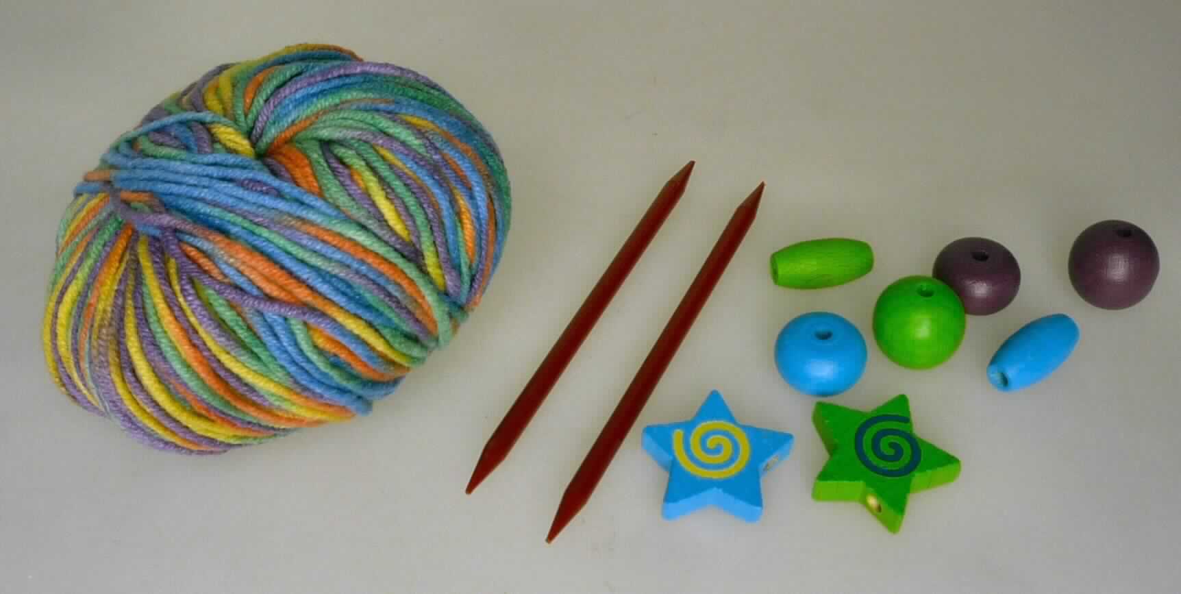 Handarbeitsset, Foto siehe Anlage,
- Warenzusammenstellung, bestehend aus einem Knäuel Garn, zwei Stricknadeln und verschiedenen Holzperlen;
  lt. Antrag gemeinsam in einem Pappkarton für den Einzelverkauf aufgemacht und zur Befriedigung eines 
  speziellen Bedarfs (Herstellung von Freundschaftsbändchen) zusammengestellt,
- Garn:
-- im Knäuel, lt. Antrag mit einem Gewicht von 25 Gramm und einer Länge von 70 m,
-- aus lt. Antrag 50 % Baumwolle und 50 % Polyacryl (synthetische Chemiefasern; lt. Antrag Spinnfasern),
-- gezwirnt; mit S-Drehung als letzter Drehung (u. a. somit kein Nähgarn),  
-- mit einem Titer von ca. 3571 dtex, somit kein Bindfaden,
-- in Aufmachung für den Einzelverkauf,
- zwei Stricknadeln:
-- augenscheinlich aus Kunststoff, mit einem Durchmesser von ca. 4 mm,
-- an beiden Seiten angespitzt,
- Holzperlen:
-- zwei "Sterne" und sechs verschiedenfarbige "Perlen" in unterschiedlichen Formen, aus Holz; mit Bohrung,
- das Stricken des Endproduktes stellt keine spielerische Basteltätigkeit dar, somit keine Ware der Position 9503,
- insbesondere im Hinblick auf die Bedeutung im Bezug auf die Verwendung verleiht das Garn der 
  Warenzusammenstellung ihren wesentlichen Charakter.

"Garn aus synthetischen Spinnfasern, kein Nähgarn, in Aufmachung für den Einzelverkauf, mit einem Anteil
 an synthetischen Spinnfasern von weniger als 85 GHT"