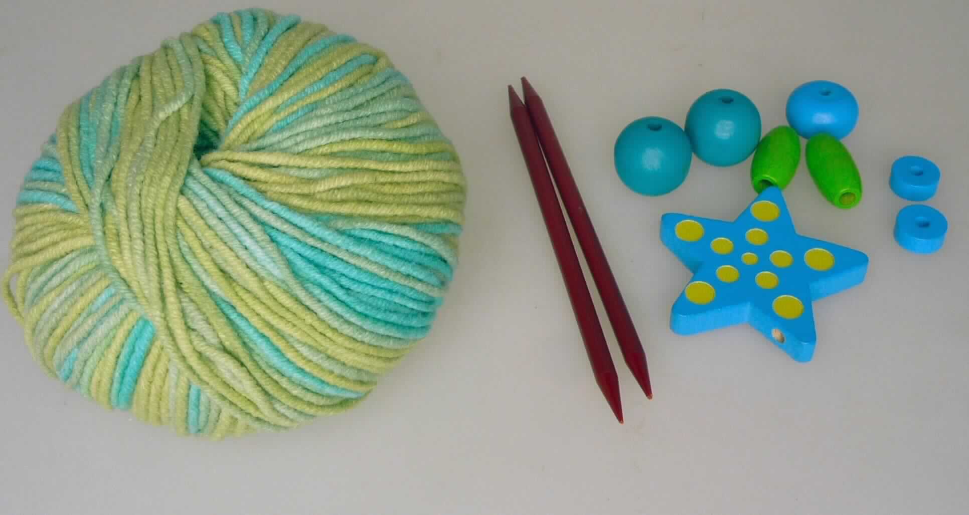 Handarbeitsset, Foto siehe Anlage,
- Warenzusammenstellung, bestehend aus einem Knäuel Garn, zwei Stricknadeln und verschiedenen Holzperlen;
  lt. Antrag gemeinsam in einem Pappkarton für den Einzelverkauf aufgemacht und zur Befriedigung eines 
  speziellen Bedarfs (Herstellung einer Handytasche) zusammengestellt,
- Garn:
-- im Knäuel, lt. Antrag mit einem Gewicht von 25 Gramm und einer Länge von 70 m,
-- aus lt. Antrag 50 % Baumwolle und 50 % Polyacryl (synthetische Chemiefasern; lt. Antrag Spinnfasern),
-- gezwirnt; mit S-Drehung als letzter Drehung (u. a. somit kein Nähgarn),  
-- mit einem Titer von ca. 3571 dtex, somit kein Bindfaden,
-- in Aufmachung für den Einzelverkauf,
- zwei Stricknadeln:
-- augenscheinlich aus Kunststoff, mit einem Durchmesser von ca. 4 mm,
-- an beiden Seiten angespitzt,
- Holzperlen:
-- ein "Stern" und sieben verschiedenfarbige "Perlen" in unterschiedlichen Formen, aus Holz; mit Bohrung,
- das Stricken des Endproduktes stellt keine spielerische Basteltätigkeit dar, somit keine Ware der Position 9503,
- insbesondere im Hinblick auf die Bedeutung im Bezug auf die Verwendung verleiht das Garn der 
  Warenzusammenstellung ihren wesentlichen Charakter.

"Garn aus synthetischen Spinnfasern, kein Nähgarn, in Aufmachung für den Einzelverkauf, mit einem Anteil
 an synthetischen Spinnfasern von weniger als 85 GHT"