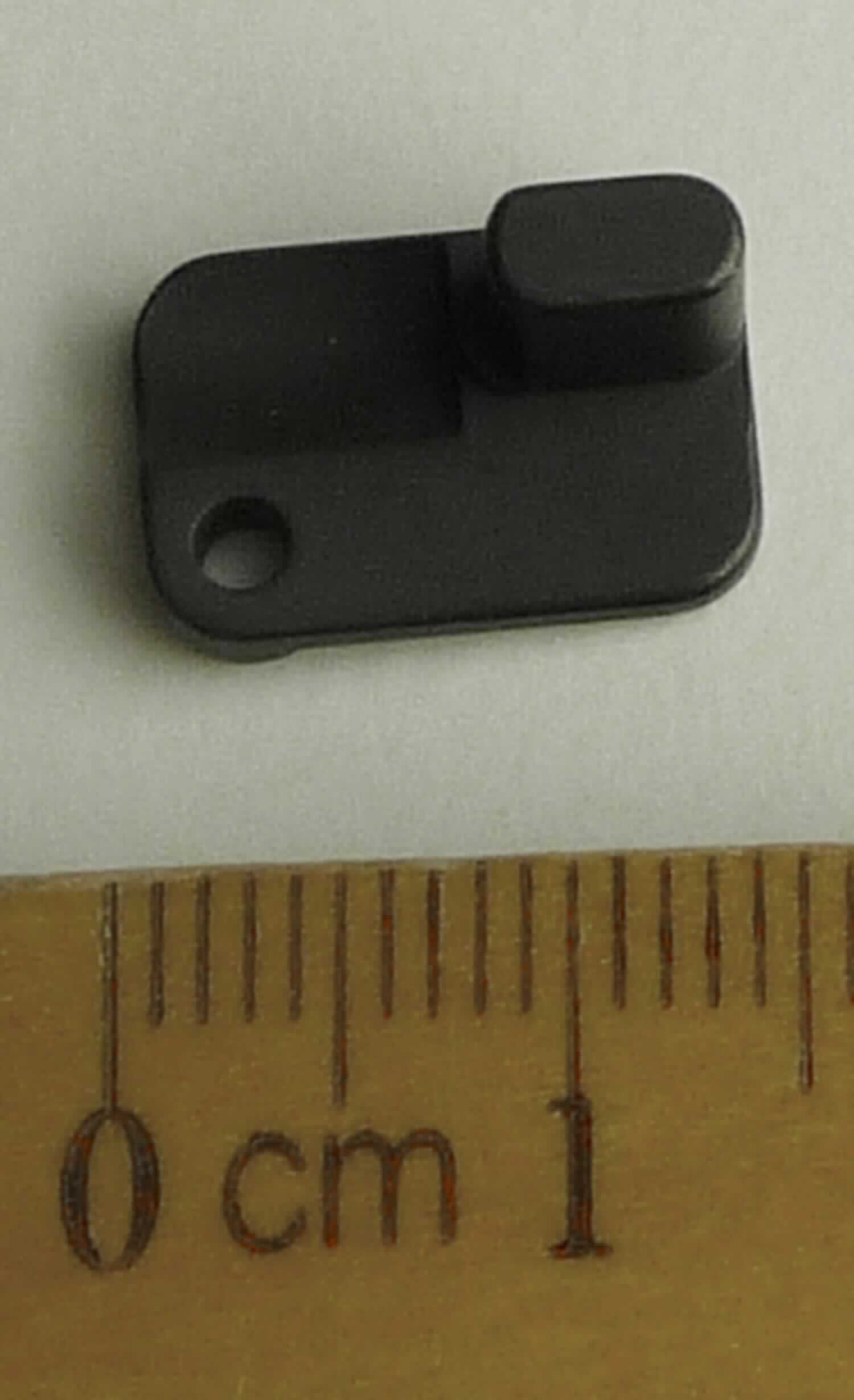 Bei der vorgelegten, als "Spannstück Ejektor links" bezeichneten Ware handelt es sich um ein spezifisch geformtes Formteil aus unedlem Metall (Abmessungen etwa 13,7 x 9,0 x 9,0 mm), das an einer Ecke eine Lochbohrung und an der diagonal gegenüberliegenden Ecke einen seitlich abstehenden, etwa ovalzylinderförmigen Zapfen (Länge etwa 6,0 mm) aufweist. Die Ware stellt sich als Teil des Auswerfer-Systems eines zweiläufigen Gewehrs (Bockflinte) dar.

Abbildung siehe Anlage.

Derartige Waren gehören als "Teile für Gewehre der Position 9303, andere als glatte Läufe" zur Codenummer 
9305 20 00 90 0 des Zolltarifs.