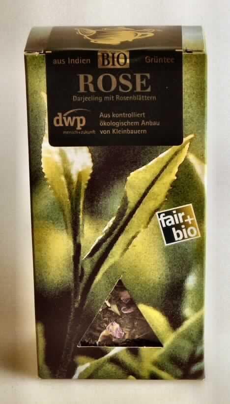 Nach den Angaben der Antragstellerin und der vorgelegten Warenprobe handelt es sich um einen so genannten Darjeeling-Grüntee "Rose". Das Erzeugnis besteht aus getrockneten, zerkleinerten Blättern vom Strauch der Gattung Thea, die mit einem geringen Anteil (Besatz) an getrockneten, zerkleinerten Rosenblütenblättern vermischt/aromatisiert sind. 
Das Erzeugnis ist in einem Polybeutel abgepackt und in einer Faltschachtel (Inhalt 90g) für den Einzelverkauf aufgemacht.