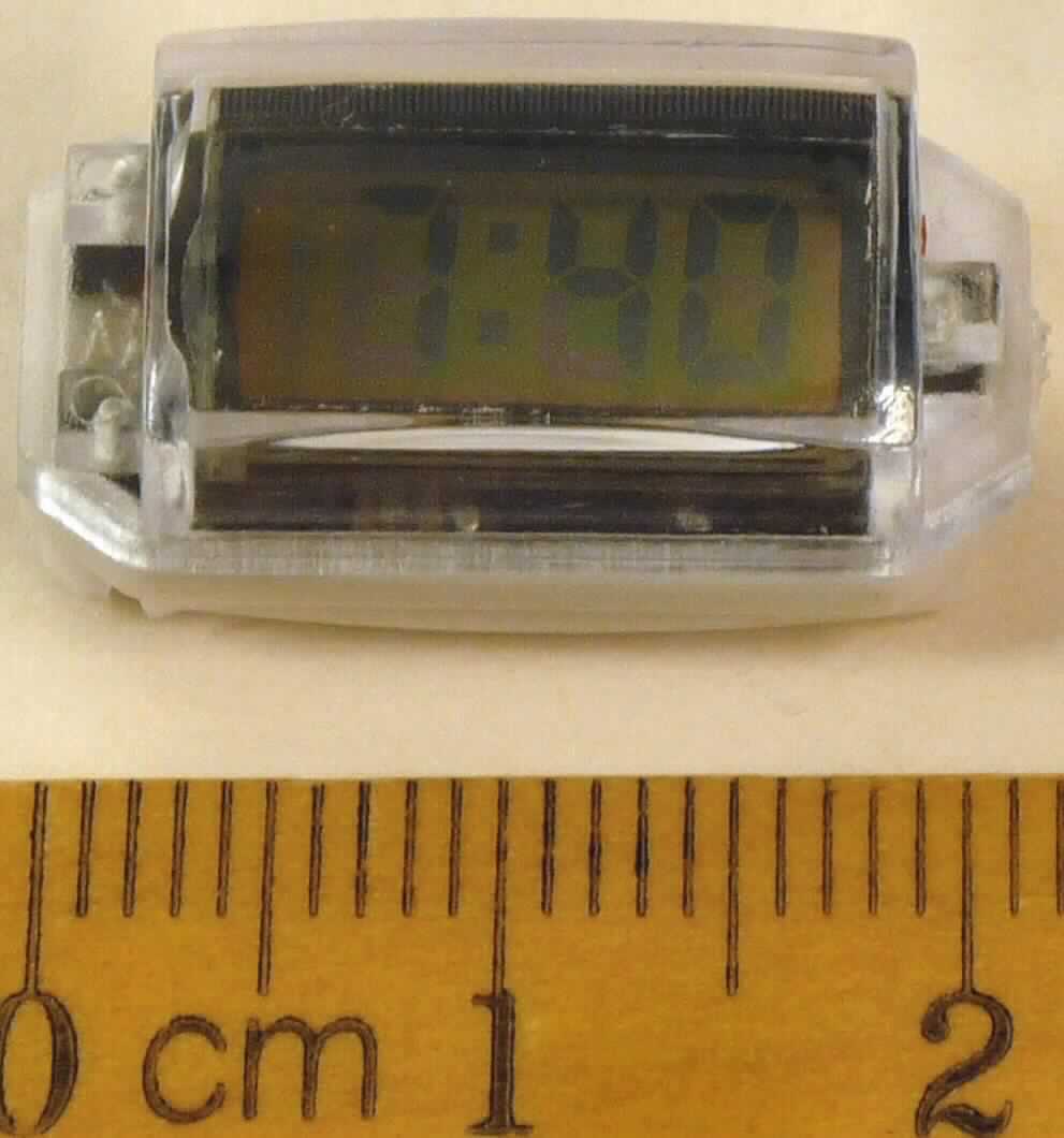 Sog. "digitales batteriebetriebenes Uhrwerk, im Wesentlichen bestehend aus einer rechteckigen, ca. 2,2 x 1,0 cm (LxD) großen Uhr in einem weißen und transparenten Kunststoffgehäuse mit einer digitalen Anzeige für Stunden, Minuten und Sekunden.
Aufgrund des Gehäuses stellt sie bereits eine vollständige Uhr dar. Sie ist dazu vorgesehen, bspw. in Armbänder, Halsketten, Geldbörsen, Taschen, Rucksäcke und Ringe eingebaut zu werden. 

Die beschriebene Ware ist als "andere als in den Positionen 9101, 9102 und 9104 erfasste Uhr mit Kleinuhrwerk, elektrisch betrieben" einzureihen.