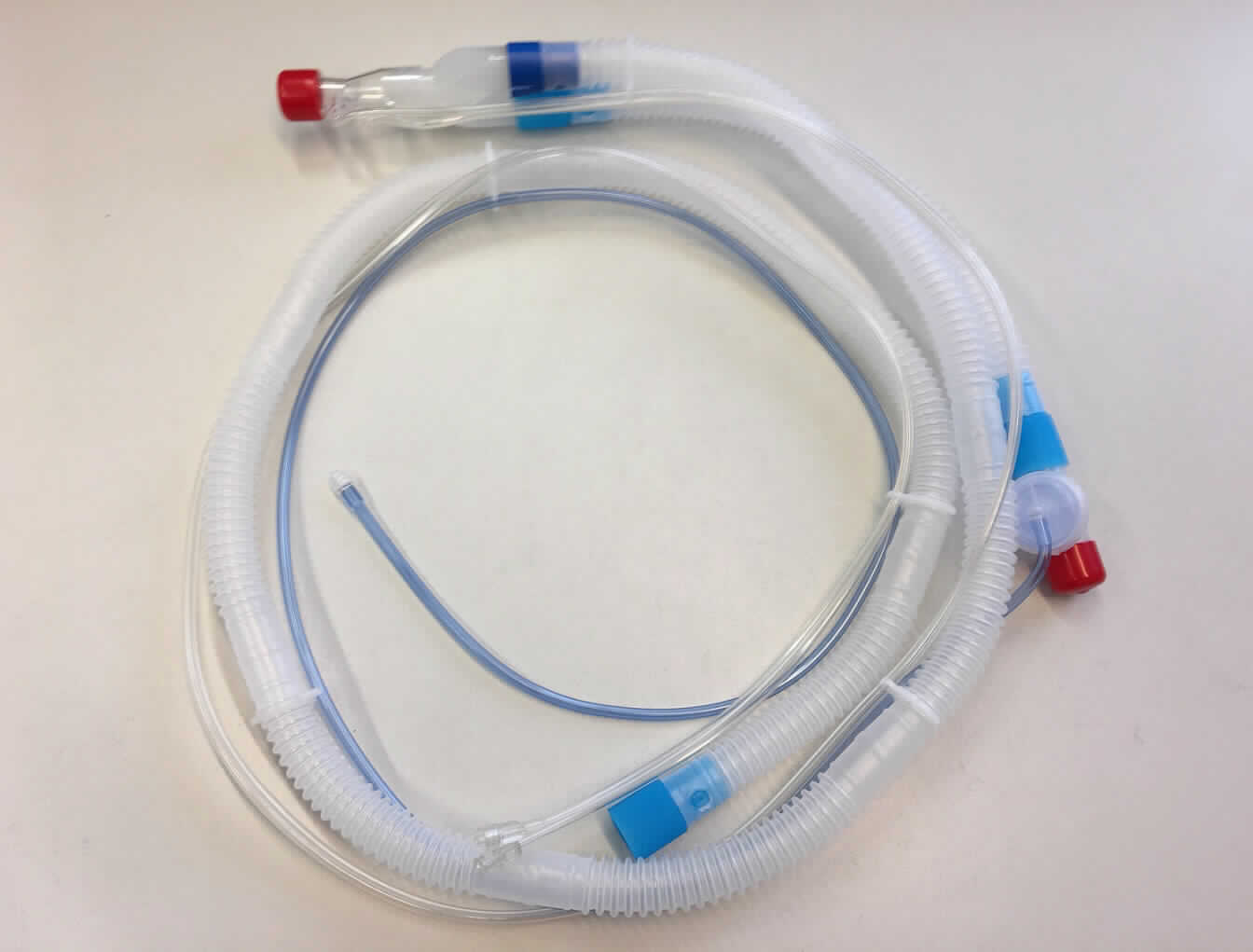 Sog. Einwegbeatmungs-Schlauchsystem, REF: M1162026, im Wesentlichen bestehend aus einem farblosen, transparenten, gerippten, biegsamen Schlauch mit einem Innendurchmesser von 22 mm, einseitig mit einem Beatmungsgeräte-Auslass (sog. Inspirationsschenkel), auf der anderen Seite mit einem Y-Stück mit aufgestecktem Kunststoffteil mit Flowsensor sowie einem ca. 34 cm langen Schlauchstück mit externem Ausatemventil. Am Außenschlauch sind mittels Kunststoff-Schlauchklemmen zwei Schläuche befestigt, einer in Form eines blauen Steuerschlauches (externe Steuerleitung des Expirationsventils) mit Luer-Lock Konnektor, welcher am externen Ausatemventil und einer in Form eines transparenten Doppelschlauches, welcher am Flowsensor angeschlossen ist (sog. Flowsensorschläuche), ebenfalls mit Luer-Lock-Konnektoren. Die Schlauchenden sind jeweils mit einer roten Kunststoffkappe verschlossen. Die Gesamtlänge des Schlauchsystems beträgt ca. 1880 mm.
Äußere Form: siehe Abbildung in der Anlage.
Das Schlauchsystem stellt ausschließlich die Verbindung zwischen dem iVent-Beatmungsgerät (nicht Gegenstand dieser vZTA-Entscheidung) und den Atemwegen des Patienten her und dient im Rahmen der maschinellen Beatmung ausschließlich dem Transfer von Atemgasen.

Die Ware, welche mit einer Anleitung in einem Kunststoffbeutel verpackt ist, wird als "Teil, erkennbar hauptsächlich für ein Beatmungsgerät bestimmt" eingereiht.