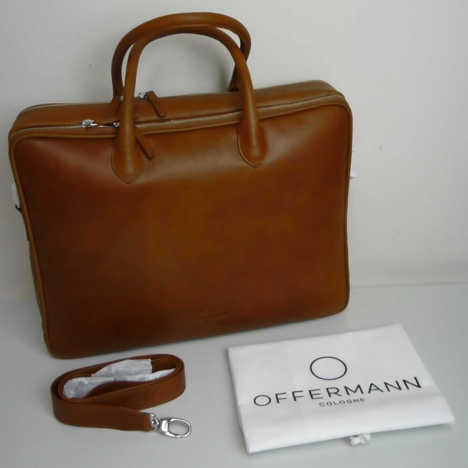 Aktentasche, sog. Damen-Businesstasche, Foto siehe Anlage,
- gemeinsam mit einem einfachen Beutel aus Spinnstoffen für den Einzelverkauf aufgemacht (der Beutel ist in
  die Aktentasche eingelegt); der Beutel ist geringwertig und im Hinblick auf die Verwendung als unbedeutend
  zu betrachten, er ändert das Wesen der Hauptware nicht und ist deshalb wie diese einzureihen,
- mit einer Außenseite aus Leder,
- mit zwei Handtragegriffen und mit einem abnehmbaren, längenverstellbaren Schultertragegurt, 
- auf einer Seite mit zwei quer verlaufenden Reißverschlüssen (zur Befestigung der Aktentasche
  an einem Trolleygestänge),
- mit zwei gefütterten Hauptfächern,
- - beide mit einem entlang der Schmalseiten und des oberen Rands verlaufenden Reißverschluss,
- - ein Hauptfach:
- - - auf einer Seite mit drei offenen Einsteckfächern und zwei Stiftlaschen, auf der anderen Seite mit einem
      Reißverschlussfach und einem abnehmbaren Lederriemen mit Karabinerhaken an den Enden ausgestattet,
- - ein weiteres Hauptfach:
- - - mit drei am Boden längs verlaufenden, starren Stäben ausgestattet,  
- in den Abmessungen: ca. 39 cm (Breite) x 30 cm (Höhe) x 10 cm (Tiefe),
- ohne Hinweise auf Handarbeit.

"Aktentasche, mit Außenseite aus Leder, nicht handgearbeitet"