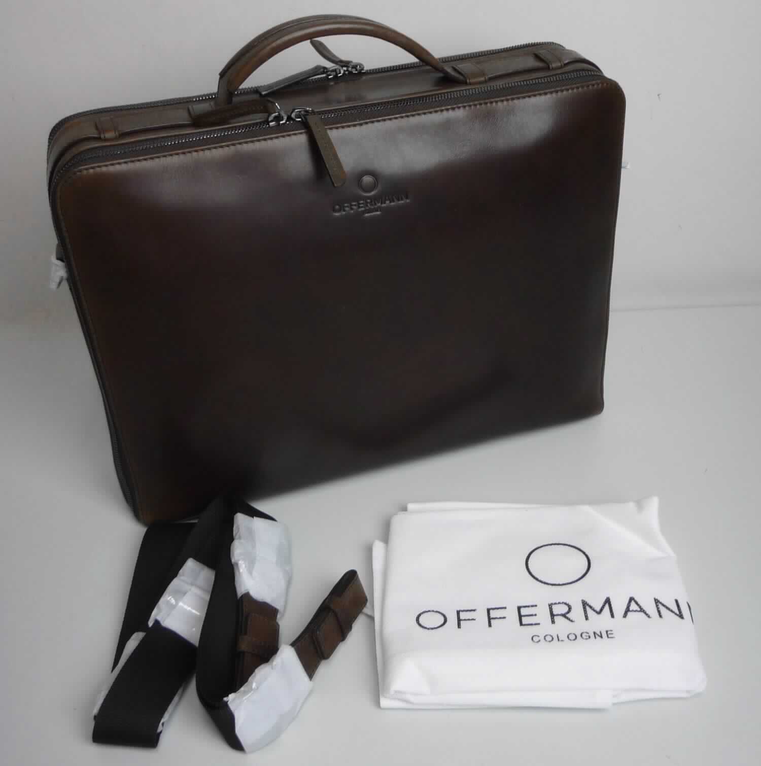 Aktentasche, sog. Businesstasche, Foto siehe Anlage,
- gemeinsam mit einem einfachen Beutel aus Spinnstoffen für den Einzelverkauf aufgemacht (der Beutel ist in
  die Aktentasche eingelegt); der Beutel ist geringwertig und im Hinblick auf die Verwendung als unbedeutend
  zu betrachten, er ändert das Wesen der Hauptware nicht und ist deshalb wie diese einzureihen,
- mit einer Außenseite aus Leder,
- mit einem Handtragegriff und mit einem abnehmbaren, längenverstellbaren Schultertragegurt, 
- auf einer Seite mit zwei quer verlaufenden Reißverschlüssen (zur Befestigung der Aktentasche an einem
  Trolleygestänge),
- mit zwei gefütterten Hauptfächern,
- - ein Hauptfach:
- - - mit einem entlang des oberen Rands verlaufenden Reißverschluss,
- - - mit einem am Boden längs verlaufenden, starren Stab ausgestattet, 
- - ein weiteres Hauptfach:
- - - mit einem entlang der Schmalseiten und des oberen Rands verlaufenden Reißverschluss,
- - - zweigeteilt; mit einem Trennsteg in Form eines Reißverschlussfachs; außen mit drei offenen Einsteck-
      fächern und zwei Stiftlaschen, 
- - - auf einer Seite mit drei am Boden längs verlaufenden, starren Stäben ausgestattet,
- - - auf der anderen Seite mit einem Reißverschlussfach und einem abnehmbaren Lederriemen mit 
       Karabinerhaken an den Enden ausgestattet,
- in den Abmessungen: ca. 39 cm (Breite) x 29 cm (Höhe) x 10 cm (Tiefe),
- ohne Hinweise auf Handarbeit.

"Aktentasche, mit Außenseite aus Leder, nicht handgearbeitet"