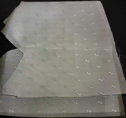 Jacquardgewebe, sog. Gewebe, Foto siehe Anlage,
- als Meterware; mit einer Breite von mehr als 30 cm,
- laut Untersuchungsergebnis:
-- aus ungezwirnten, nicht hochfesten Garnen aus nicht texturierten synthetischen Filamenten (Polyester),
-- in Musterbindung (geometrische Musterung),
-- weiß gefärbt (= gebleicht).

"Gewebe aus Garnen aus synthetischen Filamenten, anderes als in den Unterpositionen 5407 10 bis 5407 54 
 genannte, mit einem Anteil an nicht texturierten Polyester-Filamenten von mehr als 85 GHT, gebleicht"