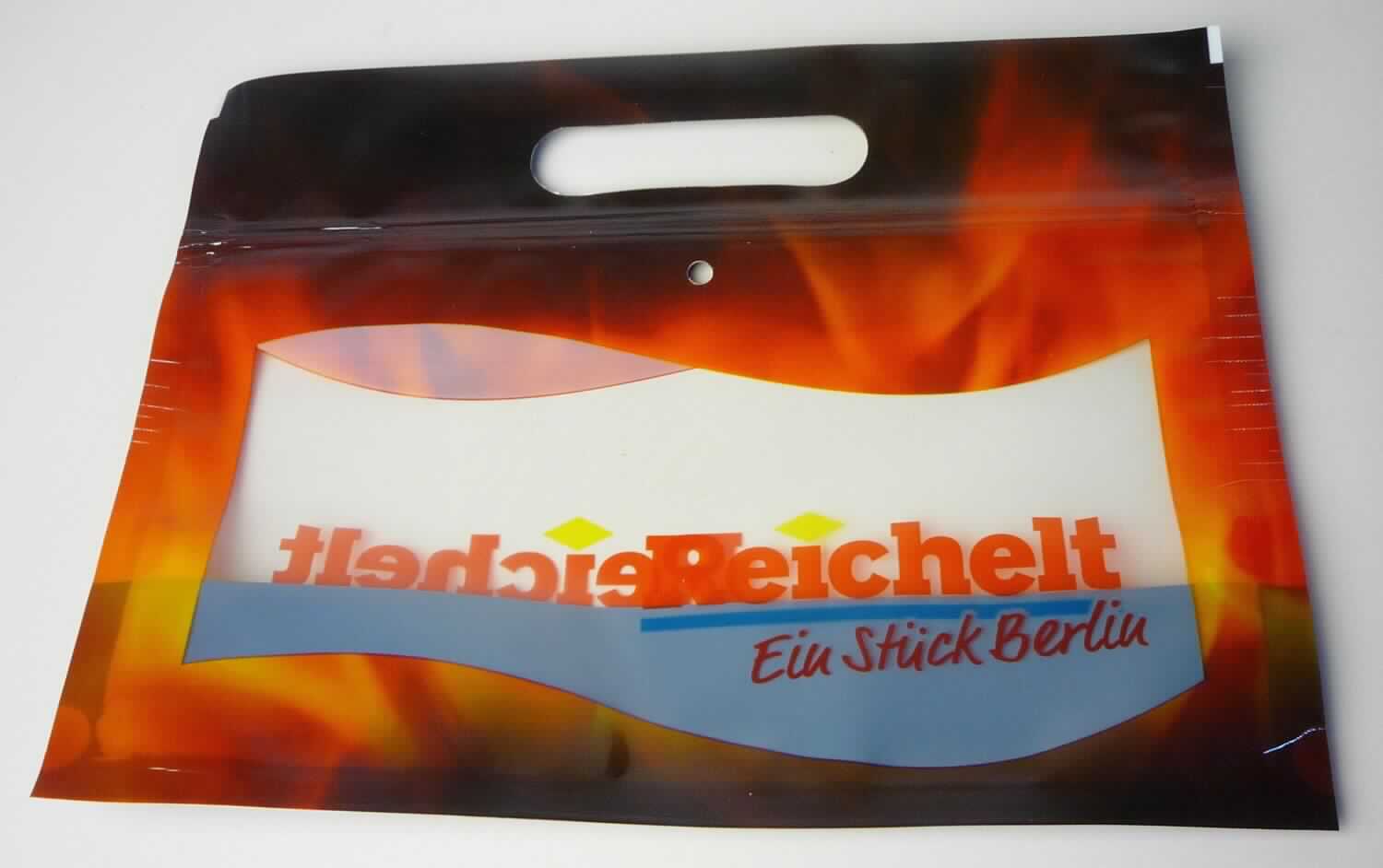 Es handelt sich um Beutel aus miteinander verschweißten Folien aus - lt. Antragsangaben - Polyethylenterephthalat (PET, Kunststoff im Sinne der Anmerkung 1 zu Kapitel 39) mit transparentem Sichtfenster, ausgestanztem Tragegriff, wiederverschließbarem Druckverschluss und einer runden Lochung.

Die farbig bedruckten Waren (ca. 19,6 x 25,3 cm) dienen als Transport- oder Verpackungsmittel für warme Grillhähnchen. 

Derartige Erzeugnisse werden zolltariflich als "Transport- oder Verpackungsmittel aus Kunststoffen, Beutel aus anderen Kunststoffen als Polymeren des Ethylens oder Polyvinylchlorid" eingereiht.