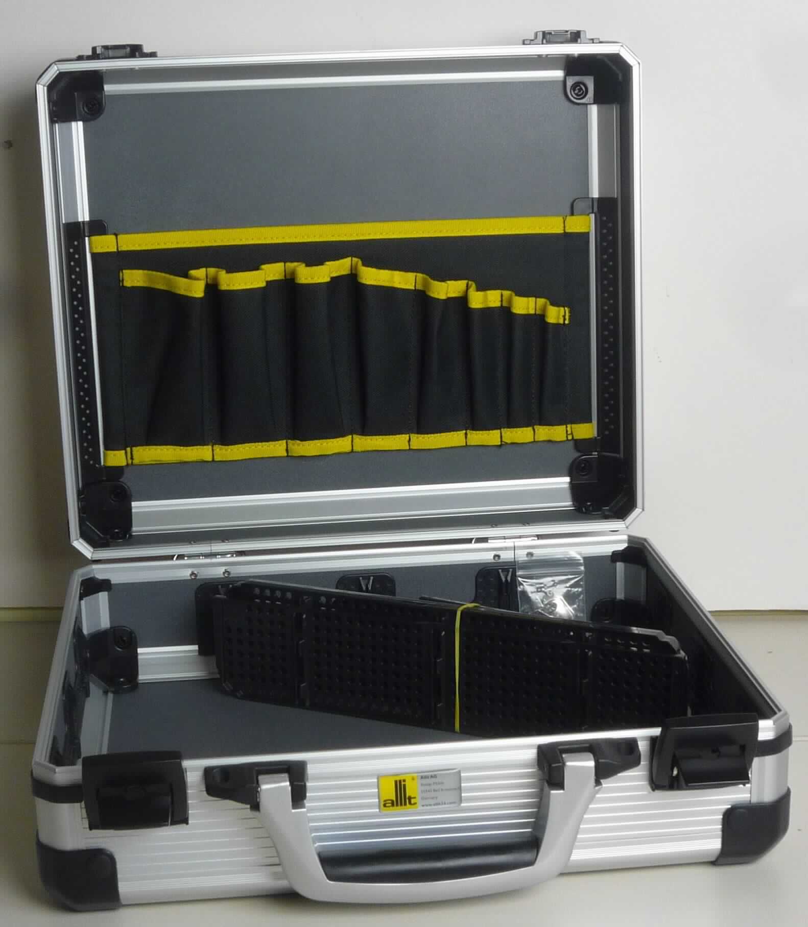Handkoffer, sog. Service- und Montagekoffer, Foto siehe Anlage,
- mit einer Außenseite aus silberfarbenen Kunststofffolien (Rillen-Profil),
  die auf einer Unterkonstruktion aus entsprechend zugeschnittenen Holzfaserplatten aufgeklebt sind,
- mit einem Rahmen aus lt. Antrag Aluminium und Eckverstärkungen aus Kunststoff,
- mit einem Handtragegriff aus Kunststoff,
- mit zwei verschließbaren Spannbügelverschlüssen,
- innen ohne weitere Einteilung,
- mit arretierbaren Trennstegen und einem Textilwerkzeughalter,
- in den Abmessungen von ca. 35,5 cm x 30,5 cm x 13,5 cm.

"Handkoffer, mit Außenseite aus Kunststofffolien"