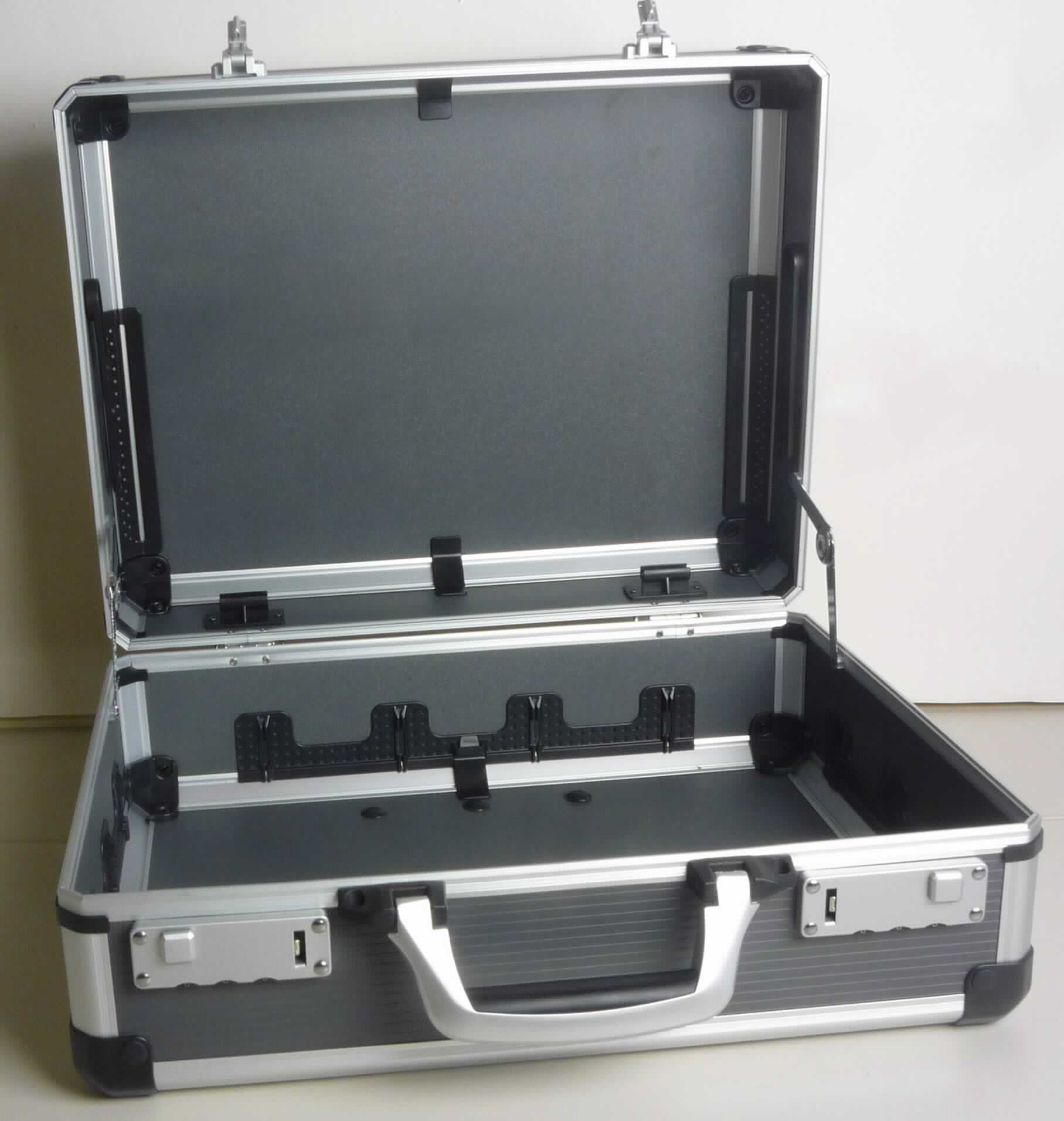 Handkoffer, sog. Service- und Montagekoffer, Foto siehe Anlage,
- mit einer Außenseite aus anthrazitfarbenen Kunststofffolien (Rillen-Profil),
  die auf einer Unterkonstruktion aus entsprechend zugeschnittenen Holzfaserplatten aufgeklebt sind,
- mit einem Rahmen aus lt. Antrag Aluminium und Eckverstärkungen aus Kunststoff,
- mit einem Handtragegriff aus Kunststoff,
- mit zwei Zahlenschlössern,
- innen ohne weitere Einteilung,
- mit Trennsteghalterungen an allen Wänden des Unterteils; mit Halterungen für Textilwerkzeughalter,
- in den Abmessungen von ca. 44,5 cm x 37,0 cm x 19,0 cm.

"Handkoffer, mit Außenseite aus Kunststofffolien"