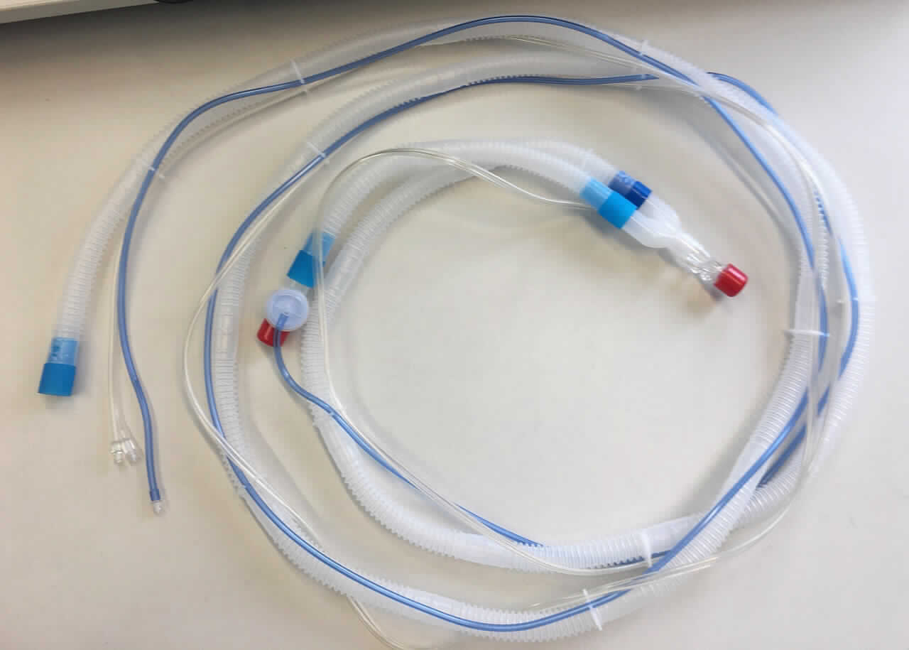Sog. Einwegbeatmungs-Schlauchsystem, REF: M1173406, im Wesentlichen bestehend aus einem farblosen, transparenten, gerippten, biegsamen Schlauch mit einem Innendurchmesser von 22 mm, einseitig mit einem Beatmungsgeräte-Auslass (sog. Inspirationsschenkel), auf der anderen Seite mit einem Y-Stück mit aufgestecktem Kunststoffteil mit Flowsensor sowie einem ca. 35 cm langen Schlauchstück mit externem Ausatemventil. Am Außenschlauch sind mittels Kunststoff-Schlauchklemmen zwei PVC-Schläuche befestigt, einer in Form eines blauen Steuerschlauches (externe Steuerleitung des Expirationsventils) mit Luer-Lock Konnektor, welcher am externen Ausatemventil und einer in Form eines transparenten Doppelschlauches, welcher am Flowsensor angeschlossen ist (sog. Flowsensorschläuche), ebenfalls mit Luer-Lock-Konnektoren. Die Schlauchenden sind jeweils mit einer roten Kunststoffkappe verschlossen. Die Gesamtlänge des Schlauchsystems beträgt ca. 4,1 Meter.
Äußere Form: siehe Abbildung in der Anlage.
Das Schlauchsystem stellt ausschließlich die Verbindung zwischen dem iVent-Beatmungsgerät (nicht Gegenstand dieser vZTA-Entscheidung) und den Atemwegen des Patienten her und dient im Rahmen der maschinellen Beatmung ausschließlich dem Transfer von Atemgasen.

Die Ware, welche mit einer Anleitung in einem Kunststoffbeutel verpackt ist, wird als "Teil, erkennbar hauptsächlich für ein Beatmungsgerät bestimmt" eingereiht.