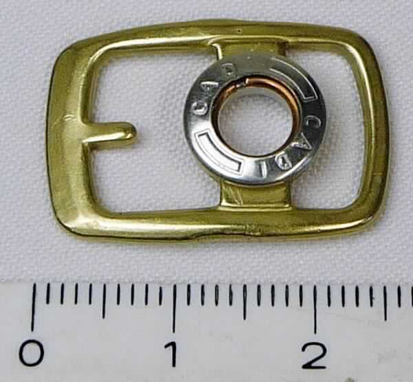Bei der aus gewalztem Stahl bestehenden Schnalle mit abgerundeten Ecken (Breite ca. 18 mm und Länge ca. 25 mm) handelt es sich um ein erkennbares Teil eines Druckknopfs, der als Schuhverschluss eingesetzt wird.

Die Ware wird als erkennbares Teil eines Druckknopfs eingereiht.