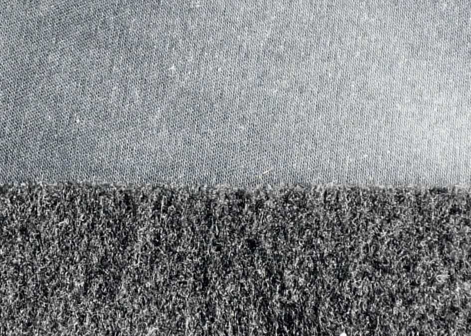 Textillaminat, sog. Möbelbezugsstoff, Foto siehe Anlage,
- als Meterware; laut Antrag mit einer Breite von etwa 145 cm,
- laut Untersuchungsergebnis:
-- aus zwei mit ihrer ganzen Fläche aufeinander liegenden und so miteinander durch Kleben verbundenen Lagen: 
--- Oberlage (Schauseite; charakterbestimmend):
---- geschmirgeltes, gefärbtes Gewebe in Köperbindung aus Kettgarnen aus synthetischen Filamenten
     (laut Antrag aus Polyester) und aus Schussgarnen aus synthetischen Mikro-Spinnfasern (Bikompo-
     nentenfasern aus Polyester (Fibrillen) und Polyamid (Matrix)); mit einem Anteil an
----- synthetischen Mikro-Spinnfasern (hauptsächlich Polyester-Spinnfasern) von 53,5 GHT,
----- synthetischen Filamenten (Polyester-Filamente) von 46,5 GHT,
--- Unterlage:
---- gefärbtes und gerautes Kuliergewirke aus synthetischen Chemiefasern (keine Elastomergarne oder
     Kautschukfäden enthaltend).

"Gewebe aus synthetischen Spinnfasern, anderes als in den Positionen 5512 - 5514 genannte, aus Polyester-
 Spinnfasern, hauptsächlich mit synthetischen Filamenten gemischt, gefärbt"