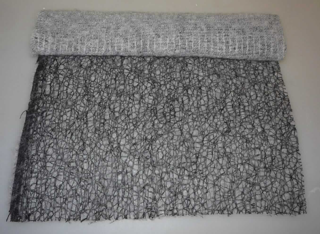 Kettengewirke, sog. Oberstoff, Art. 5352 - Saison Winter 2015, Foto siehe Anlage,
- als Meterware; laut Antrag mit einer Breite von 145 cm,
- bestehend aus einem die Schauseite bildenden, einfarbigen (schwarzen) Kettengewirke und einem in 
  Kettenwirktechnik gefertigten, buntgewirkten (teilweise unter Verwendung von melierten Garnen) Nähgewirke, 
  aus Garnen aus 46 % Polyester, 38 % Polyacryl, 11 % Polyamid (alles synthetische Chemiefasern) und 
  5 % Wolle; laut Antrag in einem Arbeitsgang hergestellt und miteinander vernadelt, 
- ohne Flor- und Schlingenoberfläche,
- keine Elastomergarne oder Kautschukfäden enthaltend,
- insgesamt buntgewirkt,
- dient laut Antrag zur Herstellung von Bekleidung; nicht für Vorhänge und Gardinen, 
- keine Raschelspitze.

"Kettengewirke, andere als solche der Positionen 6001 bis 6004, aus synthetischen Chemiefasern,
 buntgewirkt, nicht für Vorhänge und Gardinen, keine Raschelspitze"