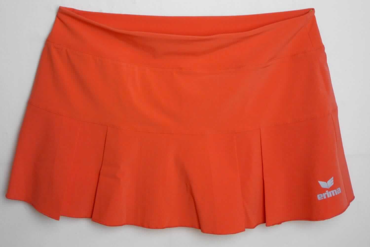Rock, sog. Tennis-Rock mit Hose/Skirt, Art. 1410701, Style 07-0061, Größe 38, Foto siehe Anlage,
- in einem bedruckten Polybeutel verpackt,
- mit einem Rockteil und einem Bund aus ca. 0,3 mm dicken, einfarbigen Geweben aus laut Antrag 
  86 % Polyester und 14 % Elasthan (beides synthetische Chemiefasern) sowie mit einem Hosenteil
  aus ca. 0,6 mm dicken, einfarbigen Gewirken aus laut Antrag 92 % Polyester und 8 % Elasthan,
- über den Schritt reichend (Seitenlänge: ca. 29 cm),
- in der Taille abschließend, mit einem angesetzten, doppelt gearbeiteten Taillenbund,
- ohne Öffnung und ohne Verschluss,
- innen mit einer dauerhaft am Bund angenähten kurzen Hose, die kürzer gearbeitet ist als der Rock,
  so dass die Hosenbeine nicht zu sehen sind,
- vorn mit einem Firmenemblem bedruckt,
- am unteren Rand des Rockes durch eine Überwendlichnaht gesäumt; an den Beinabschlüssen der 
  Hose durch Umschlagen und Festnähen gesäumt,
- nach dem Schnitt und dem Gesamteindruck handelt es sich um einen Rock,
- im Hinblick auf den Umfang und das äußere Erscheinungsbild verleihen die Gewebe der Ware ihren
  wesentlichen Charakter, somit keine Ware des Kapitels 61.

"Rock, aus Gewirken, für Frauen, aus synthetischen Chemiefasern, nicht nach dem Batik-Verfahren handbedruckt"