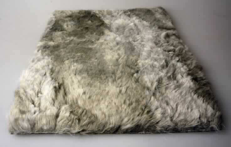 Textillaminat, Foto siehe Anlage,
- als Meterware, mit einer Breite von laut Antrag 145 cm,
- aus zwei mit ihrer ganzen Fläche aufeinander liegenden und so miteinander durch Kleben verbundenen Lagen, 
  laut Untersuchungsergebnis bestehend aus:
-- Schauseite:
--- einem etwa 1,5 cm dicken Hochflorerzeugnis / Plüschgewirke aus synthetischen Chemiefasern,
--- mit Prägung versehen (Fellimitat),
-- Unterseite:
--- einem etwa 2 mm dicken, einfarbigen Gewebe aus Baumwolle,
--- geraut,
--- gefärbt,
--- mit einem Quadratmetergewicht von weniger als 200 g,
- nach dem Umfang und in Bezug auf die Verwendung bestimmt das Hochflorerzeugnis / Plüschgewirke den 
  Charakter der Ware.

"Textillaminat aus einem Plüsch ("Hochflorerzeugnis"), gewirkt (charakterbestimmend), aus synthetischen 
 Chemiefasern und einem Gewebe aus Baumwolle, mit einem Anteil an Baumwolle von mehr als 85 GHT und 
 einem Quadratmetergewicht von weniger als 200 g"