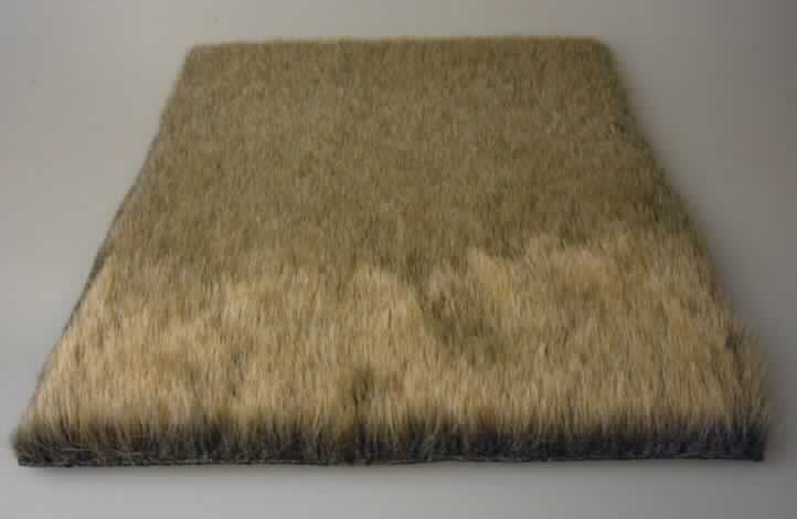 Textillaminat, Foto siehe Anlage,
- als Meterware, mit einer Breite von laut Antrag 145 cm,
- aus zwei mit ihrer ganzen Fläche aufeinander liegenden und so miteinander durch Kleben verbundenen Lagen,
  laut Untersuchungsergebnis bestehend aus:
-- Schauseite:
--- einem etwa 1,5 cm dicken Hochflorerzeugnis / Plüschgewirke aus synthetischen Chemiefasern,
--- mit Prägung versehen (Fellimitat),
-- Unterseite:
--- einem etwa 2 mm dicken, einfarbigen Gewebe aus Baumwolle,
--- geraut,
--- gefärbt,
--- mit einem Quadratmetergewicht von weniger als 200 g,
- nach dem Umfang und in Bezug auf die Verwendung bestimmt das Hochflorerzeugnis / Plüschgewirke den 
  Charakter der Ware.

"Textillaminat aus einem Plüsch ("Hochflorerzeugnis"), gewirkt (charakterbestimmend), aus synthetischen 
 Chemiefasern und einem Gewebe aus Baumwolle, mit einem Anteil an Baumwolle von mehr als 85 GHT und 
 einem Quadratmetergewicht von weniger als 200 g"