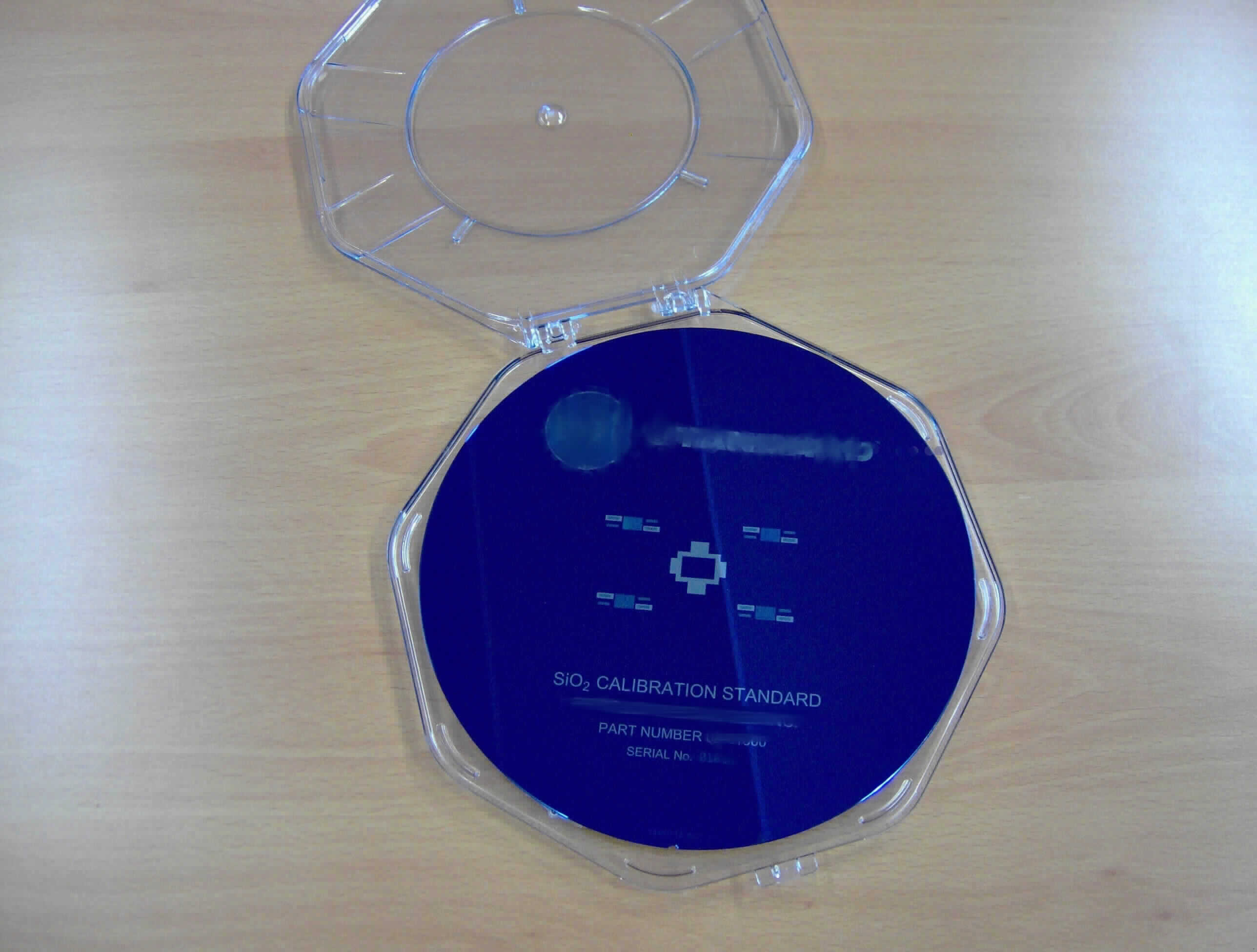 SiO2-Standard-Wafer zur Kalibration von Schichtdickenmessgeräten

Angaben des Anmelders:
200-mm-Waferkalibrierstandards aus Silicium, u.a mit dem Aufdruck einer "part number" und einer "serial number". Auf den Wafern sollen sich Felder mit einer Schicht aus thermisch abgeschiedenem Siliciumdioxid oder Aluminiummetall genau definierter, einheitlicher  Schichtdicke befinden. Die Wafer sollen zur Kalibrierung von optischen Schichtdickenmessgeräten in der Halbleiterindustrie verwendet werden. Sie werden von einem individuellen Zertifikat begleitet und sind auf NIST-Primärstandards rückführbar.

Feststellungen: 
Es wurden Fotos von Wafern mit Seriennummer und ein Muster eines Zertifikat mit Anlage vorgelegt. Darin finden sich Angaben u.a. zur Identifikation des Waferkalibrierstandards, zur zertifizierten Schichtdicke inkl. Unsicherheit, zur Rückführbarkeit auf NIST-Primärstandards und zu Details zur angewandten Messmethodik (Ellipsometrie).

Befund:
Zertifizierte Referenzmaterialien
Das beigefügte Zertifikat erfüllt die Anforderung der Anmerkung 2 A) zu  Kapitel  38 der Kombinierten Nomenklatur.