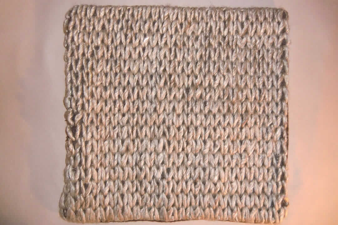 Zierkissenhülle, sog. Kissenhülle, Foto siehe Anlage,
- quadratisch; laut Antrag mit den Abmessungen: 45 cm x 45 cm,
- mit einer Vorderseite (Schauseite) aus einer Stickerei der Position 5810 mit einem nicht sichtbaren Grund 
  aus Spinnstoffen und Stickfäden aus laut Antrag 70 % Wolle, 20 % Viskose (künstliche Chemiefasern) und 
  10 % Nylon (synthetische Chemiefasern), mit Vliesstoffen unterlegt,
- einer Rückseite aus geschmirgelten, buntgewebten Geweben (melierte Garne) aus laut Antrag 70 % Wolle, 
  20 % Viskose und 10 % Nylon,
- durch Zusammennähen konfektioniert,
- auf der Rückseite mit einer ca. 35 cm langen Öffnung zum Einstecken eines Kissens; mit verdecktem 
  Reißverschluss mit zwei Verriegelungsstiften (u. a. somit keine Ware der Position 6302),
- ohne Polsterung oder Füllung, somit keine den Bettausstattungen ähnliche Ware der Position 9404.

"Andere Ware zur Innenausstattung (Zierkissenhülle), keine Ware der Position 9404, aus Spinnstoffen, nicht aus Gewirken oder Gestricken, aus Wolle und künstlichen Chemiefasern"