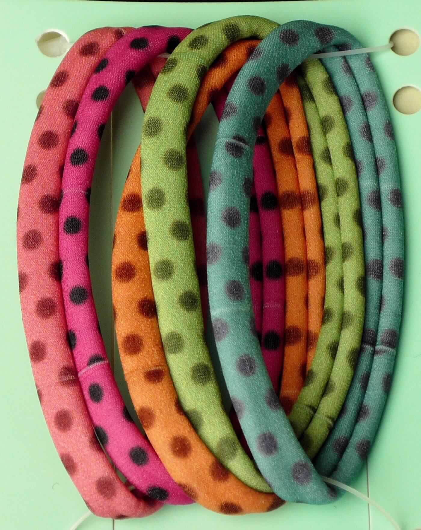 Gewirke, sog. Zopfhalter bunt mit Tupfen, Art. LAN 11477, Foto siehe Anlage,
- als fünfteiliges Sortiment auf einer bedruckten Pappkarte aufgebracht,
- jeweils:
-- bestehend aus einem bedruckten, schlauchförmigen, aufgerollten Gewirke ohne Schlingen- oder Floroberfläche,
-- flachliegend mit einer Breite von bis zu ca. 5 cm,
-- laut Antrag aus 60 % Polyamid und 40 % Elasthan (Elastomergarn; beides synthetische Chemiefasern),
-- nur geschnitten (nicht konfektioniert).

"Gewirke mit einer Breite von weniger als 30 cm und mit einem Anteil an Elastomergarnen von mehr als 5 GHT,
 andere als solche der Position 6001, keine Kautschukfäden enthaltend, aus synthetischen Chemiefasern"