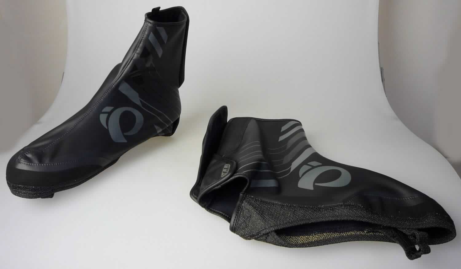 Gamaschen (lt. Antrag: "Mountain Bike Überziehschuh, Art.14381606 - PRO BARRIER WXB MTB SHOE COVER", Foto siehe Anlage)
- aus mehreren zusammengenähten Zuschnitten aus Spinnstofferzeugnissen, die einen Überzug aus (lt. Antrag)
  Kunststoff oder Kautschuk aufweisen,
- Teile des Fußes und des Unterschenkels bedeckend,
- ohne Sohle, im Bodenteil lediglich mit einem Steg unterhalb des Fußgewölbes, einem Halteband im Zehenbereich 
  sowie einer Randverstärkung,
- hinten mit Klettverschluss,
- mit einer Höhe von ca. 24 cm

"Gamaschen"