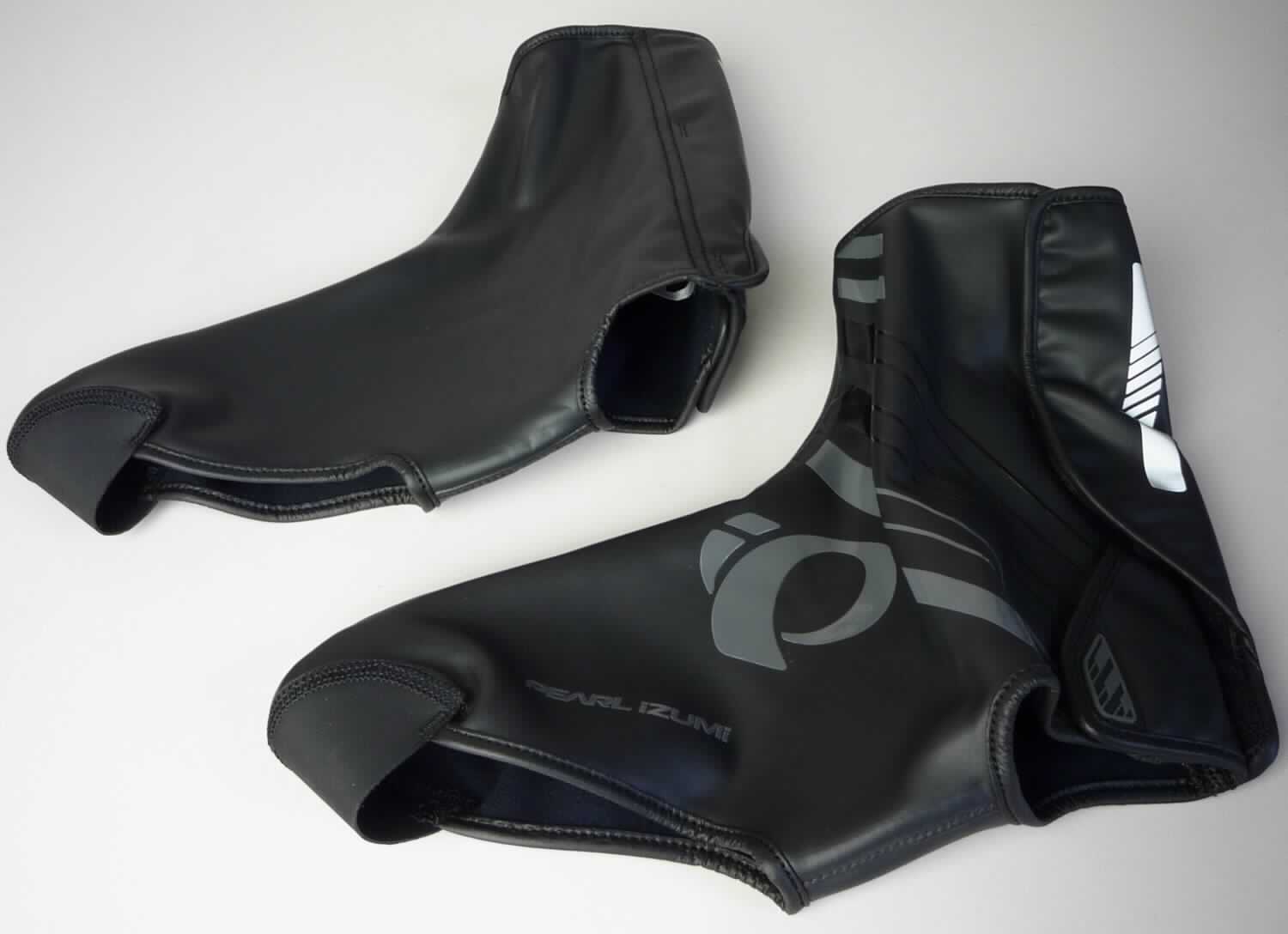 Gamaschen (lt. Antrag: "Wasser- und windabweisender Radüberziehschuh, Art. 14381602, PRO BARRIER WXB SHOE COVER", Foto siehe Anlage)
- aus mehreren zusammengenähten Zuschnitten aus Spinnstofferzeugnissen, die einen Überzug aus (lt. Antrag)
  Kunststoff oder Kautschuk aufweisen,
- Teile des Fußes und des Unterschenkels bedeckend,
- ohne Sohle, im Bodenteil lediglich mit einem Steg unterhalb des Fußgewölbes und einem aufgenähten 
  halbkreisförmigen Zuschnitt im Zehenbereich,
- hinten mit Klettverschluss,
- mit einer Höhe von ca. 24 cm

"Gamaschen"