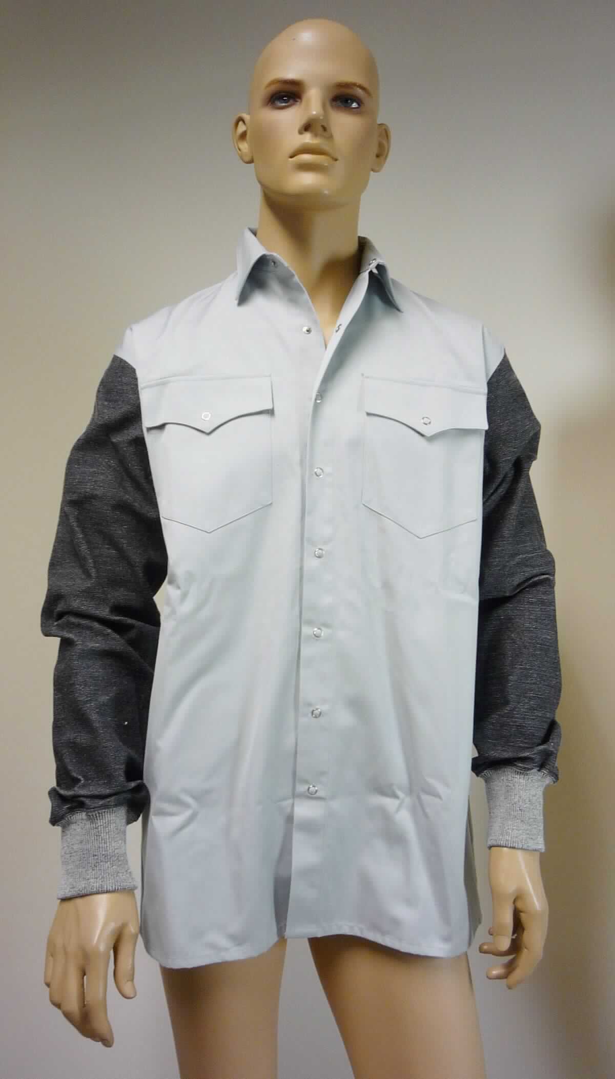 Hemd, sog. Hemd mit Schnittschutz, Art. 8689, Größe 40, Foto siehe Anlage,
- aus ca. 0,5 mm dicken, einfarbigen Geweben aus laut Antrag 60 % Baumwolle und 40 % Polyester 
  (synthetische Chemiefasern); mit Ärmeln aus ca. 1,2 mm dicken, buntgewirkten Gewirken (melierte Garne) aus 
  65 % Chemiefasern (laut Antrag: 43 % Dyneema/Bambus sowie 22 % Elasthan) und 35 % Glasfasern,
- über den Schritt reichend (Rückenlänge: ca. 80 cm),
- mit einem Umlegekragen,
- vorn mit einer durchgehenden Öffnung mit Druckknopfverschluss von links über rechts (Männerkleidung),
- mit langen Ärmeln, an den Ärmelenden mit doppelt gearbeiteten Bündchen,
- mit zwei aufgesetzten Brusttaschen mit Patte und Knopfverschluss,
- am unteren Rand durch Umschlagen und Festnähen gesäumt,
- keine Einreihung als Arbeits- und Berufskleidung, da innerhalb der Position 6205 keine Unterposition für 
  Arbeits- und Berufskleidung vorgesehen ist,
- im Hinblick auf den Umfang und das äußere Erscheinungsbild bestimmen die Gewebe den Charakter der Ware.

"Hemd, aus Geweben, für Männer, aus Baumwolle, nicht nach dem Batikverfahren handbedruckt"