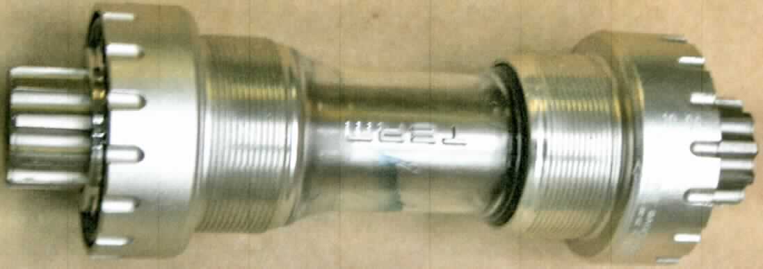Teil für Fahrrad, sog. Innenlager/Tretlager, Foto siehe Anlage,
- zylinderförmiges Gehäuse aus unedlem Metall mit innen liegenden Lagerschalen in 
  denen die Tretlagerwelle gelagert wird,
- an den Enden zum Anbringen der Tretkurbeln bzw. des Kettenblattes hergerichtet
- erkennbares Teil der Kurbelgarnitur eines Fahrrades.

"Teil für Fahrräder der Position 8712, Teil einer Kurbelgarnitur (Tretlager)"