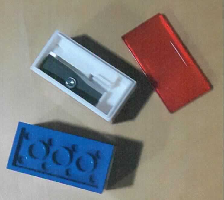"Spitzer"

- bestehend aus einem quaderförmigen Gehäuse aus Kunststoff, in der Form eines Legosteins,
  mit einer auswechselbaren, geschliffenen Klinge aus unedlem Metall

- mit einer abnehmbaren Kappe aus Kunststoff versehen

- zu je zwei Stück auf einer Pappunterlage aufgeblistert

Abbildung siehe Anlage.

Derartige Erzeugnisse gehören als "andere Schneidwaren (Bleistiftspitzer) mit arbeitendem Teil aus unedlem Metall" zum TARIC-Code 8214 1000 00.