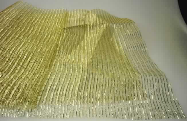 Kettengewirke, sog. Dekorationsstoff, Muster B, siehe Foto
- als Meterware,
- in den Abmessungen laut Antrag von 300 cm x 145 cm,
- laut Untersuchungsergebnis 
- - aus 55 % goldfarbenen, metallisierten Garnen (etwa 1 mm breite, metallisierte Streifen 
    aus synthetischer Spinnmasse) und 45 % Garnen aus synthetischen Chemiefasern,
- - buntgewirkt,
- - ohne Flor- oder Schlingenoberfläche,
- - keine Elastormergarne oder Kautschukfäden enthaltend,
- - an den Längskanten heiß geschnitten, jedoch nicht gesäumt, somit nicht konfektioniert,
    damit keine Ware der Position 6307.

"Kettengewirke, andere als solche der Positionen 6001 bis 6004, aus metallisierten 
 Streifen aus synthetischer Spinnmasse"