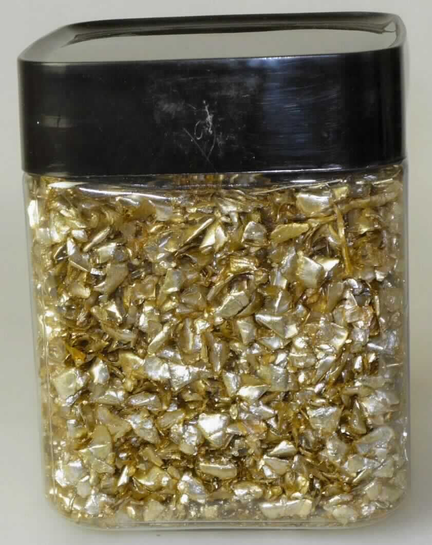 Angaben des Antragstellers:
Metallic Flitter 5 - 10 mm
Zerkleinerte Polyethylen (LDPE)-Aluminiumfolie (ca. 8 mm) in verschiedenen Farben zu Dekorationszwecken.

Untersuchungsergebnisse an einem Warenmuster:
Zerkleinerte (zerrissene), farblose, zweilagige Kunststofffolie (Polyethylen (Dicke: ca. 140 µm), Polyethylenterephthalat (Dicke: ca. 15 µm), die auf der Polyethylenterephthalatseite mit einer silberfarbenen Aluminiumschicht (Dicke: ca. 15 µm) und Goldfarbe überzogen ist (siehe Abbildung).

Befund:
Die vorliegenden Stücke stellen sich als Kunststoff in Primärform dar. Aufgrund der Zusammensetzung liegt ein Ethylen-Copolymer im Sinne der Position 3901 vor.