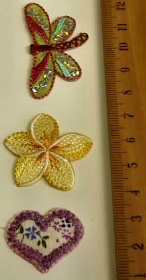 Stickerei, sog. Stickereiapplikation, Art. 347500, Foto siehe Anlage,
- auf einer Pappunterlage in einem Polybeutel aufgemacht,
- in unterschiedlichen Motiven (Blume, Herz, Libelle) in den Abmessungen:
  etwa 3 cm x 3 cm, 2,5 cm x 2,5 cm bzw. 4,5 cm x 2,5 cm,
- auf einem Stickgrund aus Gewebe mit Stickgarnen bestickt, beide aus laut Antrag Chemiefasern,
- das Motiv "Libelle" ist mit aufgenähten Pailletten aus Kunststoff versehen (Applikationsstickerei), 
- auf der Rückseite, zum Aufbügeln, mit Kunststoff ausgestattet, 
- nicht handgearbeitet,
- laut Antrag mit einem Wert von mehr als 17,50 EUR je kg Eigengewicht.

"Stickerei als Motiv, andere als Ätzstickereien und Stickereien mit herausgeschnittenem
 Grund, aus Chemiefasern, mit einem Wert von mehr als 17,50 EUR je kg Eigengewicht, nicht
 handgearbeitet"