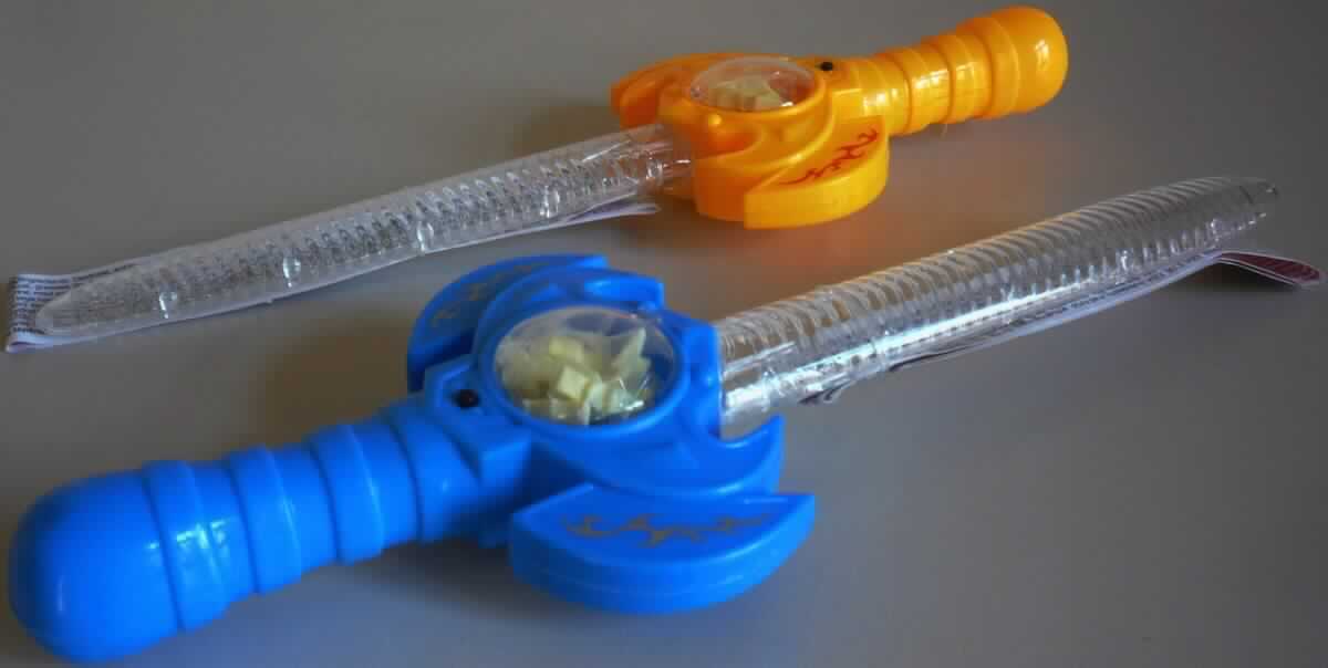 Kombination aus Spielzeug und Süßigkeiten (sog. Magic Sword) in Form eines Kunststoff-Schwerts mit Musik-Funktion, gefüllt mit Dextrose-Komprimaten im Griff, bestehend aus
- einem ca. 28 cm langen Schwert
-- aus Kunststoff hergestellt, mit einer klarsichtigen, geraden Klinge
-- mit einem orangefarbenen Griff mit einem batteriebetriebenen Soundmodul, das durch Drücken eines kleinen
   Knopfes aktiviert wird und Geräusche eines Schwertkampfes wiedergibt
-- mit einem Hohlraum im Griff mit einem klarsichtigen, abnehmbaren Deckel
- darin befindet sich eine Tüte mit Dextrosekomprimaten mit Apfelgeschmack (Inhalt 3 g) in Blitzform
- mit einer angeklebten Anleitung mit Sicherheitshinweisen und Angabe der Inhaltsstoffe, die zusätzlich mit einem
  Gummiband an der Klinge fixiert ist, für den Einzelverkauf aufgemacht.

Die Kombination hat den wesentlichen Charakter von Spielzeug und dient der spielerischen Unterhaltung von Kindern und Erwachsenen.

Die Ware ist als "Spielzeugwaffe, nicht handgearbeitet aus Holz" einzureihen.