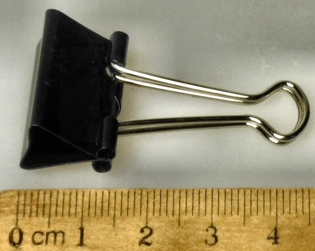 Es handelt sich um aus unedlem Metall gefertigte Klemmvorrichtungen aus einem etwa 25 mm breiten Blechzuschnitt, der zu einem geraden Prisma gebogen ist. An der Spitze des Prismas sind zwei aus Draht gebogenen Bügel beweglich befestigt, mit denen die unter Spannung stehende Klammer geöffnet werden kann. Die Erzeugnisse dienen zum Zusammenhalten von Papierseiten etc. 

Abbildung siehe Anlage.

Derartige Erzeugnisse gehören als "den Briefklammern und Aktenklammern ähnliches Büromaterial aus unedlen Metallen" zur Codenummer 8305 9000 00 0 des Zolltarifs.