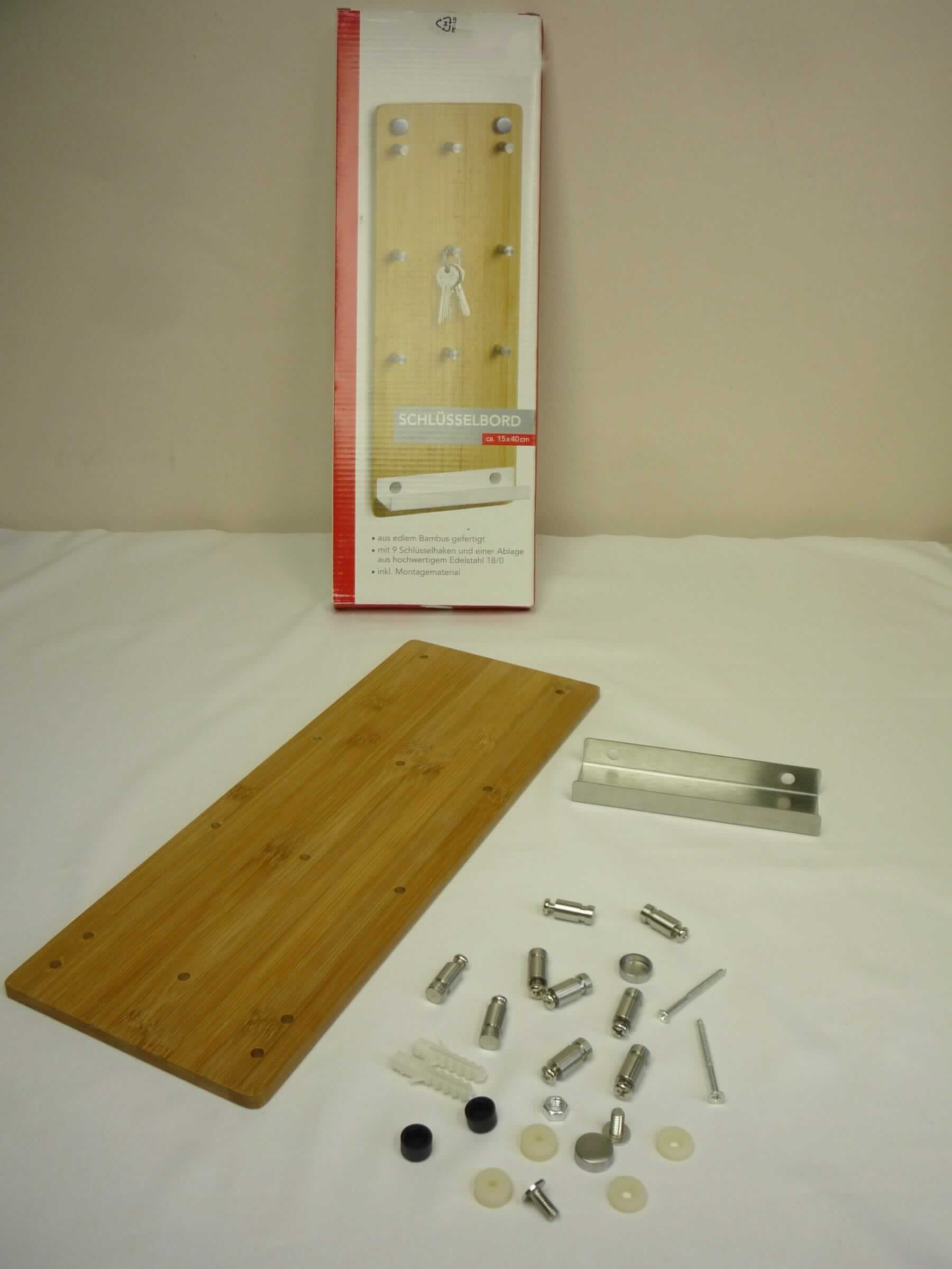 Bei dem als "Schlüsselbord Bamboo/Edelstahl" (Art. 13878) bezeichneten Erzeugnis handelt es sich um eine Warenzusammenstellung in Aufmachung für den Einzelverkauf, bestehend aus einem Schlüsselbord und nicht charakterbestimmenden Montagematerial für die Wandmontage (Dübel und Schrauben) sowie einer Montageanleitung.
Das noch nicht zusammengesetzte Schlüsselbord mit den Abmessungen 15 x 40 cm (B x H) besteht im Wesentlichen aus einem Regalboden aus Edelstahl, der auf einer zur Wandbefestigung dienenden Platte aus Bambus, die mit mehreren Schlüsselhaken versehen ist, befestigt ist. 

Der Charakter der aus zwei Stoffen bestehenden Ware wird durch den Bambus im Hinblick auf die Bedeutung für die Verwendung als tragendes Teil und durch das äußere Erscheinungsbild bestimmt. Hinweise auf Handarbeit liegen nicht vor.

Das in einem Pappkarton verpackte Erzeugnis wird als "anderes als von den Positionen 9401 und 9402 sowie den Unterpositionen (HS) 9403 10 bis 9403 70 erfasstes Möbel, nicht handgearbeitet" eingereiht.