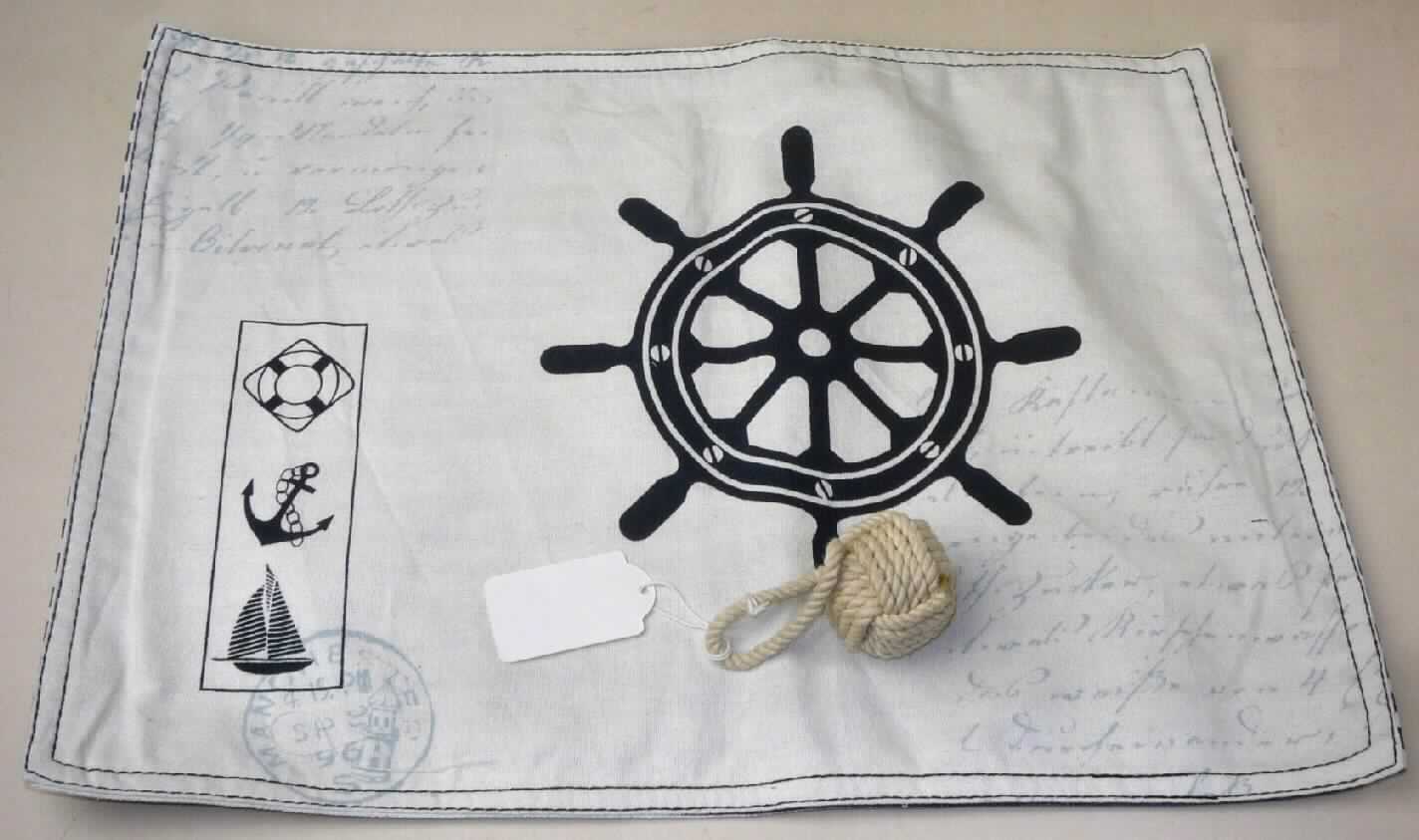 Platzset, sog. Maritime Platzmatte mit Tampen, Foto siehe Anlage,
- bestehend aus einer Platzmatte und einem sog. Tampen, 
- als Warenzusammenstellung in einem Polybeutel verpackt, zur Befriedigung eines speziellen Bedarfs 
  zusammengestellt und für den Einzelverkauf aufgemacht,
- Platzmatte (Tischwäsche):
-- rechteckig; in den Abmessungen (L x B): ca. 44 cm x 31 cm,
-- doppellagig gearbeitet; aus zwei verschiedenen, bis zu 0,6 mm dicken, bedruckten Geweben; beide aus 
   laut Antrag 100 % Baumwolle; nicht nach dem Batik-Verfahren handbedruckt,
-- an den Rändern jeweils umgeschlagen und zusammengenäht (somit konfektioniert),
-- dient als Gedeckunterlage zur Verwendung bei Tisch,
-- wird laut Antrag üblicherweise gewaschen und kennzeichnet sich aufgrund des Materials und des 
   Verwendungszwecks als Tischwäsche,
- Tampen (Ware aus Seilen):
-- auf der Außenseite vollständig aus einem in sich verknoteten Seil aus laut Antrag Baumwolle (Spinnstoffgarne 
   mit einem Titer von augenscheinlich mehr als 20.000 dtex); an einem Ende zu einer Schlaufe gelegt, 
-- mit einer Unterlage aus einem Quader aus augenscheinlich Holz,
-- durch Zusammenfügen konfektioniert,
-- insbesondere im Hinblick auf den Umfang und die Zierwirkung bestimmen die Seile aus Spinnstoffen den 
   Charakter des Tampen,
-- der Tampen dient in Art eines Serviettenringes zum Zusammenhalten der eingerollten Platzmatte,
- nach dem Umfang und der Bedeutung in Bezug auf die Verwendung bildet die Tischwäsche den 
  charkterbestimmenden Bestandteil der Warenzusammenstellung.

"Tischwäsche, aus Spinnstoffen, aus Geweben, aus Baumwolle, nicht nach dem Batik-Verfahren handbedruckt"