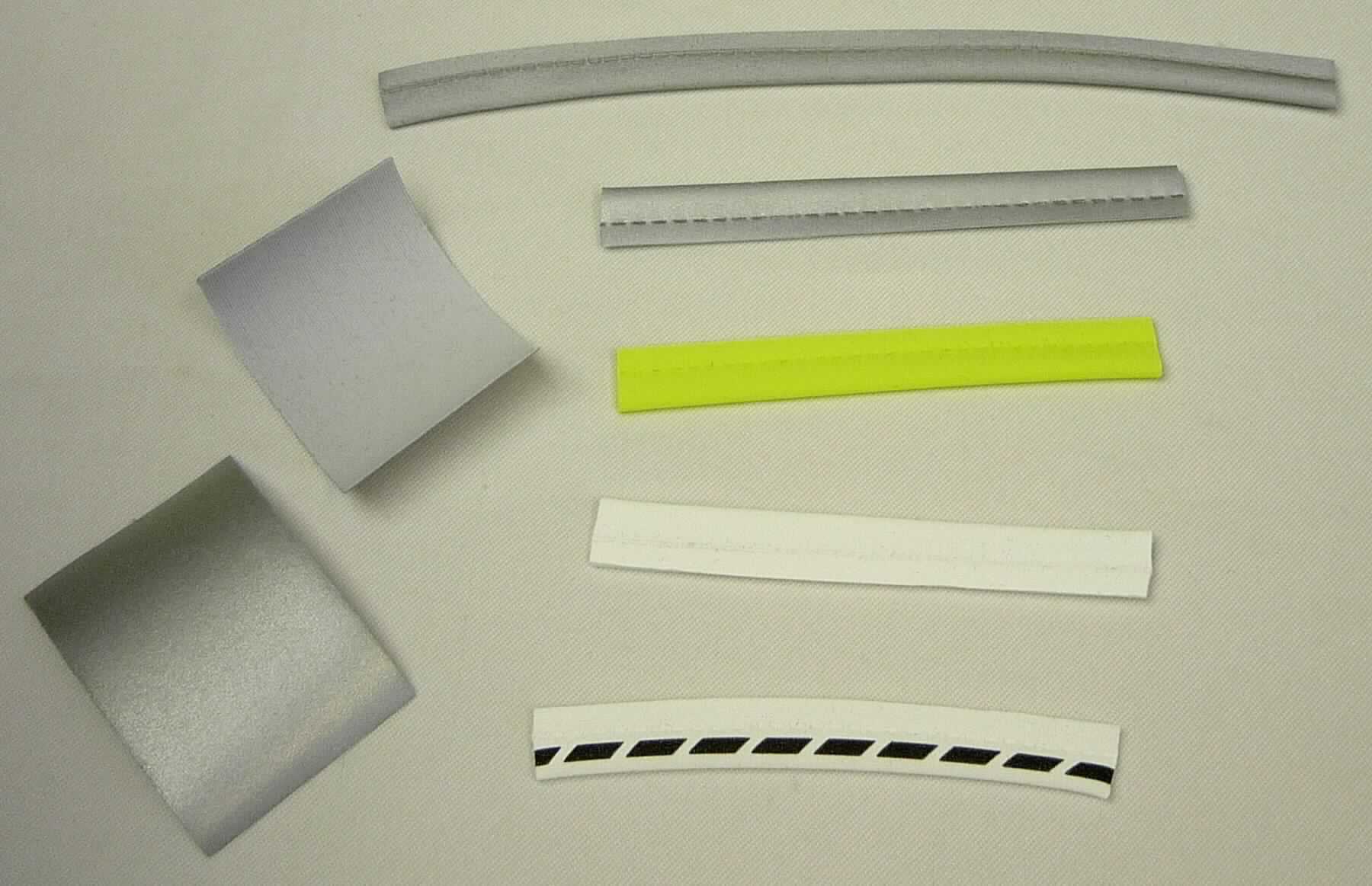 Bestrichenes Gewebe, sog. Material aus einseitig aluminiumbedampften Glaskügelchen, Art. 417F, Foto siehe Anlage,
- laut Antrag als Meterware,
- mit einer Gesamtdicke von ca. 0,4 mm,
- laut Untersuchungsergebnis:
-- aus einem Gewirke (= Gewebe i. S. d. Kapitels 59) aus laut Antrag 100 % Chemiefasern,
-- mit einer reflektierenden Schicht; bestrichen mit Klebstoff und flächendeckend überdeckt mit nicht vollständig 
   eingebetteten, laut Antrag mit Aluminium bedampften (metallisierten) Mikro-Glaskugeln (mit einem Durchmesser 
   von deutlich weniger als 150 µm),
- das Überziehen ist mit dem bloßen Auge wahrnehmbar.

"Bestrichenes Gewebe, anderes als in den Positionen 5901 bis 5906 genannte, beschichtet mit in Klebstoff 
 eingebetteten Kügelchen mit einem Durchmesser von nicht mehr als 150 µm"
