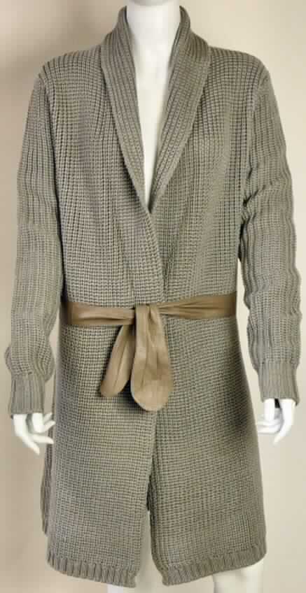Zweiteilige Warenzusammenstellung, bestehend aus einem Mantel und einem Bindegürtel, sog. Strickmantel Gipsy Point Jacket W1175, 
Größe S, siehe Foto,
- gemeinsam für den Einzelverkauf aufgemacht und zur Befriedigung eines speziellen Bedarfs zusammengestellt,
- Mantel:
-- aus bis zu 5 mm dicken Gestricken aus lt. Antrag 100 % Merinowolle,
-- über den halben Oberschenkel reichend (Rückenlänge: 92 cm),
-- mit Kragen,
-- vorn mit einer durchgehenden Öffnung ohne Verschluss, 
-- ohne Hinweise auf den Trägerkreis (unisex),
-- mit langen Ärmeln, 
-- in Taillenhöhe mit Gürtelschlaufen, 
-- am unteren Rand abgepasst gewirkt,
-- wird im Allgemeinen über jeder anderen Kleidung und zum Schutz gegen das Wetter getragen,
- Bindegürtel:
-- aus Leder,
-- ca. 130 cm lang und ca. 4,5 cm breit,
- nach Wert und Umfang bestimmt der Mantel den Charakter der Warenzusammenstellung.

"Warenzusammenstellung aus einem Mantel (kein Poncho; charakterbestimmend), aus Geweben, für Frauen, aus Wolle, und einem Gürtel aus Leder"