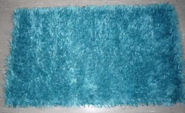 Teppich, siehe Foto,
- aus einem Gewebe mit Flor; laut Antrag aus Polyester (synthetische Chemiefasern),
- in rechteckiger Form hergestellt, mit den Abmessungen (flachliegend) von ca. 113 cm x 67 cm,
- an den Schmalseiten durch Umschlagen und Festnähen gesäumt (konfektioniert),
- kein Kelim, Sumak, Karamanie oder denen ähnlicher Teppich; nicht handgewebt,
- weder getuftet noch beflockt,
- kein Axminster-Teppich,
- kennzeichnet sich aufgrund seiner Festigkeit, Dicke und Widerstandsfähigkeit als Fußbodenbelag.