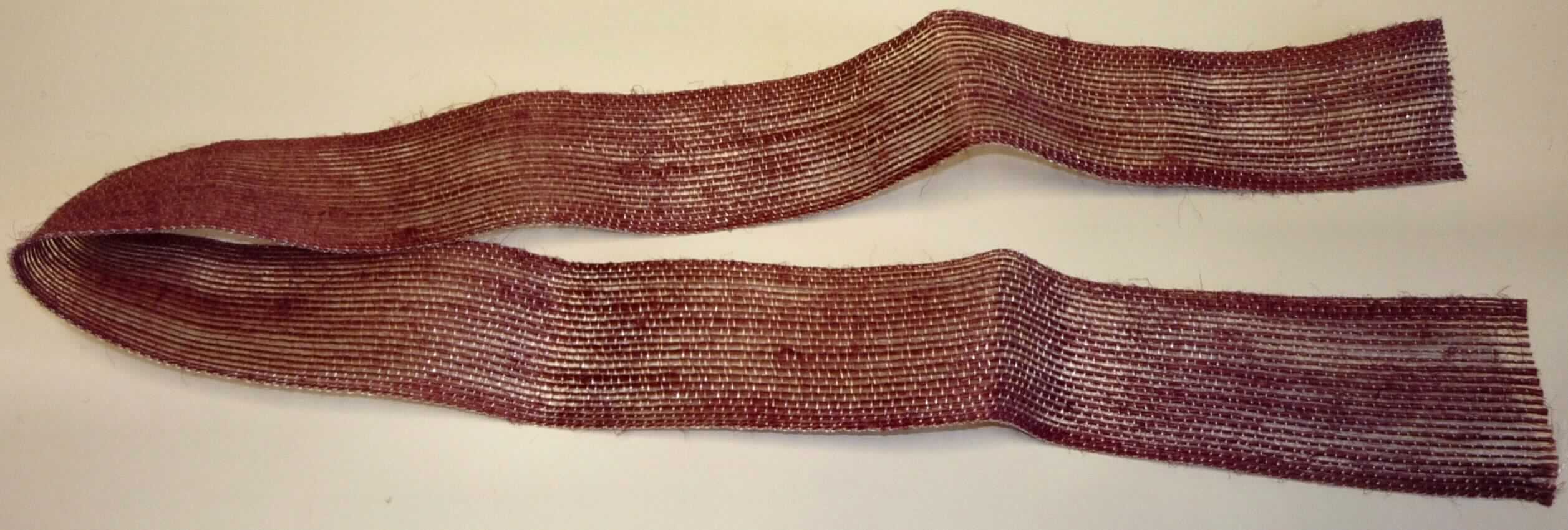 Band, sog. Geschenkband Cambric-Bastit, Foto siehe Anlage,
- laut Antrag als Meterware mit einer Länge von 3 m und einer Breite von ca. 4 cm,
- aus einem Gewebe mit Schussfäden aus synthetischen Monofilen (laut Antrag: Polyester) und Kettfäden aus 
  Garnen aus pflanzlichen Spinnstoffen (laut Antrag: Flachs und Ramie),
- laut Antrag mit einem Anteil an synthetischen Monofilen von 15,23 GHT und an pflanzlichen Spinnstoffen von 
  84,77 GHT,
- mit echten Webkanten an beiden Längsseiten,
- keine Elastomergarne oder Kautschukfäden enthaltend.

"Band, keine Ware der Position 5807, kein Samt, Plüsch, Chenille- oder Schlingengewebe, keine Elastomergarne 
 oder Kautschukfäden enthaltend, aus Flachs und Ramie"