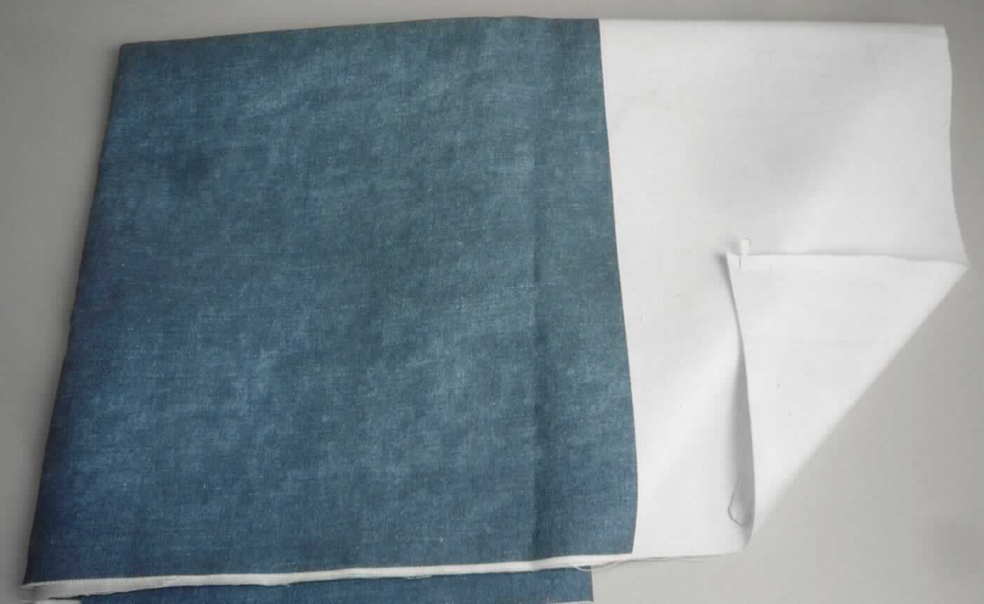 Textillaminat, sog. Gewebe, Foto siehe Anlage,
- als Meterware; mit einer Breite laut Antrag von mehr als 30 cm,
- laut Untersuchungsergebnis: 
-- aus zwei mit ihrer ganzen Fläche aufeinander liegenden und so miteinander durch Kleben verbundenen Lagen:
--- mit einer Oberlage (Schauseite):
---- aus einem bedruckten Gewebe in Ripsbindung (andere als Leinwand- oder Köperbindung) aus Kett- und 
      Schussgarnen aus Reißspinnstoff (Baumwolle, Polyester- und Viskose-Spinnfasern mit einer geringen 
      Beimischung von u.a. Leinen, Polyamid-Spinnfasern sowie Elastomergarnen)
----- mit einem Gesamtanteil an:
------ Polyester-Spinnfasern (synthetische Spinnfasern) von ca. 45 GHT, 
------ Viskose-Spinnfasern (künstliche Spinnfasern) und Polyamid-Spinnfasern (synthetische Spinnfasern) von 
        zusammen ca. 15 GHT; somit keine Ware des Kapitels 52,
------ Baumwolle von ca. 35 GHT,
------ Leinen von ca. 5 GHT,
---- mit einem Quadratmetergewicht von ca. 280 g,
--- mit einer Unterlage:
---- aus einem weißen Gewebe in Leinwandbindung aus sythetischen Filamenten,
- insbesondere im Hinblick auf die Verwendung zur Polsterung von Möbeln bestimmt das die Schauseite bildende
  Gewebe den Charakter der Ware.

"Gewebe aus synthetischen Spinnfasern, mit einem Anteil an diesen Fasern von weniger als 85 GHT, 
 hauptsächlich mit Baumwolle gemischt, mit einem Quadratmetergewicht von mehr als 170 g, bedruckt, aus 
 Polyester-Spinnfasern, in Ripsbindung "