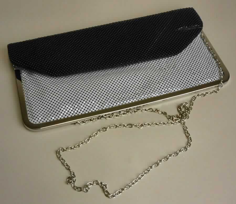 Handtasche (Theatertasche), sog. Party-Tasche, Foto siehe Anlage, 
- mit einem Handtaschenkörper aus einer Spinnstofflage mit einer Unterlage aus Schaumkunststoff und Pappe,
- mit einer Außenseite aus unedlen Metallen,
- - überwiegend aus verketteten, mit weißer bzw. schwarzer Farbe überzogenen Metallplättchen und -ringen,
- - mit einer Randeinfassung aus silberfarbenem, unedlem Metall, 
- mit einem Schultertrageriemen in Form einer Gliederkette aus unedlem Metall, 
- mit einem Hauptfach, 
- - mit einer Überschlagklappe mit Magnetknopfverschluss zu öffnen,
- - innen mit einem aufgenähten Einsteckfach; ansonsten ohne weitere Einteilung oder Ausstattung, 
- in den Abmessungen: ca. 29 cm (Breite) x 14 cm (Höhe) x 1 cm (Tiefe), 
- aufgrund der Form, der Größe und des Gesamteindrucks in erster Linie dazu geeignet, kleinere persönliche
  Gegenstände aufzunehmen.

"Handtasche, mit einem Taschenkorpus aus Spinnstoffen und einer Außenseite aus unedlen Metallen"