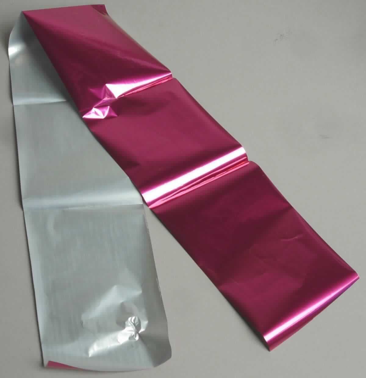 Angaben:
Prägefolie zum Aufdruck auf Kosmetikprodukte; die Folien sind Rollenwaren in verschiedenen Größen und Farben.

Feststellungen:
Metallic-pinkfarbene Folie (Rückseite silberfarben); unter Anwendung von Druck und Wärme lässt sich die pinkfarbene Beschichtung auf eine Unterlage (z.B. Papier) übertragen.

Befund: 
Prägefolie