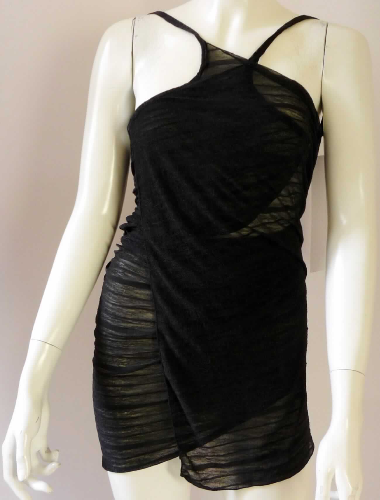 Kleid, sog. Wickelpareo, Art. Wenzhou # 785022, in Erwachsenengröße, Foto siehe Anlage,
- wird in Art eines Wickelkleides getragen,
- aus ca. 0,4 mm dicken, einfarbigen Gewirken aus laut Antrag 100 % Polyester (synthetische Chemiefasern), 
- über den Schritt reichend (Rückenlänge in getragenem Zustand: ca. 92 cm),
- mit schmalen Schulterträgern (sog. Spaghettiträger), 
- im Bereich des oberen Rückens rückenfrei,
- am unteren Rand durch Umschlagen und Festnähen gesäumt,
- kann aufgrund der Länge ohne ein weiteres, den Unterkörper bedeckendes Kleidungsstück getragen werden.

"Kleid, aus Gewirken, für Frauen, aus synthetischen Chemiefasern"