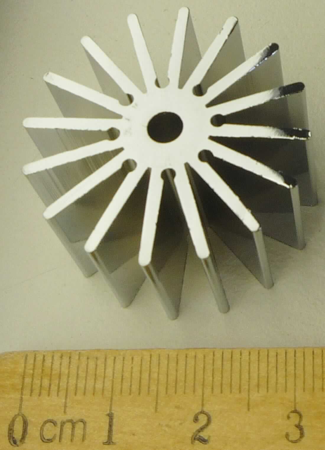 Der sog. "Kühlkörper" besteht im Wesentlichen aus einem zylindrischen Radialkühlkörper aus Aluminium mit Kühllamellen (Durchmesser ca. 32 mm, Höhe ca. 18 mm), der neben der notwendigen Kühlfunktion gleichzeitig als Träger der Lampenaufhängung und als gestalterisches Element einer LED-Leuchte dient. Der Kühlkörper ist durch das transparente Lampengehäuse zu sehen und stellt ein besonderes Designelement der fertigen Leuchte dar.


Der Kühlkörper ist als "Teil für einen Beleuchtungskörper aus Aluminium, nicht für Luftfahrzeuge bestimmt und nicht handgearbeitet" einzureihen.