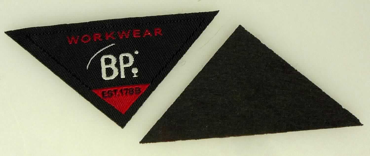 Etikett, sog. BP Workwear Dreieck, Art. 504368-0000-0001, Foto siehe Anlage,
- als Einzelstück dreieckig zugeschnitten; mit einer Länge von ca. 6 cm und einer Höhe von ca. 3 cm,
- aus einem zweilagigen, durch Kleben miteinander verbundenen Flächenerzeugnis mit einer Außenlage aus 
  buntgewebten Geweben aus lt. Antrag 100 % Polyester (synthetische Chemiefasern) und einer Innenlage aus 
  augenscheinlich Vliesstoffen aus Spinnstoffen,
- mit eingewebten Inschriften und Motiven,
- mit Kanten, die durch Heißschneiden gegen Ausriefeln gesichert sind und keine deutlichen Schmelzkanten 
  aufweisen (= nicht gesäumt / damit nicht weitergehend konfektioniert),
- nicht bestickt,
- insbesondere im Hinblick auf die Verwendung bestimmt das die Schauseite bildende Gewebe den Charakter 
  der Ware.

"Etikett, aus Spinnstoffen, zugeschnitten, nicht bestickt, gewebt, mit eingewebten Inschriften oder Motiven"