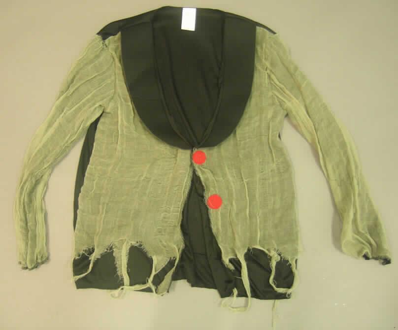 Vierteilige Zusammenstellung, bestehend aus einer Jacke, einer langen Hose, einem Bekleidungszubehör und einer Kopfbedeckung, sog. Vampirkostüm, Größe 52, Artikel-Nr. 086572
- in gemeinsamer Aufmachung für den Einzelverkauf,
- getrennte Einreihung aller Bestandteile, da Jacke und lange Hose nicht aus dem gleichen Flächenerzeugnis 
  hergestellt sind und demnach keine Kombination darstellen, 
- gehört als Maskenkostüm aus Spinnstoffen nicht zum Warenkreis der Karnevalsartikel der Position 9505,
- Jacke:
-- aus 0,5 mm dicken, einfarbigen Gewirken, 
-- Ärmel und Vorderteile mit einer Außenlage aus 0,3 mm dicken, einfarbigen, undichten Geweben; beide 
   Flächenerzeugnisse aus laut Antrag 100% synthetischen Chemiefasern,
-- über die Taille reichend (Rückenlänge: 74 cm); im unteren Teil des Kleidungsstückes ist die Gewebelage 
   unregelmäßig zacken- bzw. fetzenförmig zugeschnitten,
-- mit einem Reverskragen aus dreilagigen Spinnstofferzeugnissen mit zwei Außenlagen aus Gewirken und einer 
   Zwischenlage aus Schaumkunststoff,   
-- vorn mit einer durchgehenden Öffnung mit einem punktuellen Klettverschluss von links über rechts (Männer- 
   kleidung); mit langen Ärmeln; ungefüttert; 
-- kennzeichnet sich aufgrund des Schnitts (nur ein punktueller Klettverschluss) als Jacke (somit kein Hemd 
   der Position 6205),
-- die Gewirke sind flächenmäßig vorherrschend, die Gewebe sind nach dem Erscheinungsbild im Hinblick 
   auf die Verwendung als Maskenkostüm charakterbestimmend; keines der beiden Flächenerzeugnisse verleiht 
   der Ware somit ihren wesentlichen Charakter; sie ist damit der von den gleichermaßen in Betracht kommenden 
   Positionen (6103 und 6203) in der Nomenklatur zuletzt genannten zuzuweisen.