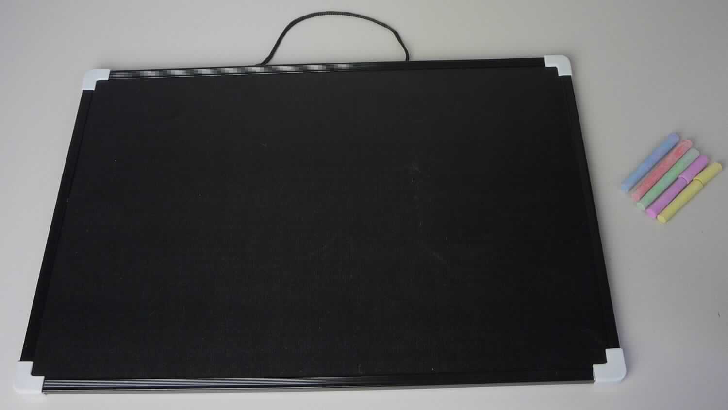 Bei dem vorliegenden Warenmuster (Art. 793133) handelt es sich um eine Warenzusammenstellung in Aufmachung für den Einzelverkauf bestehend aus einer Tafel zum Beschreiben (44,5 cm x 29,5 cm) und verschiedenfarbigen Kreidestücken (5 Stück in einem Kunststoffbeutel mit Clipverschluss). Die Tafel besteht aus Pappe, die auf der Vorderseite mit geschwärztem, zum Beschreiben geeigneten Papier beklebt ist. Sie ist mit einem Kunststoffrahmen sowie am oberen Rand mit einem als Aufhängevorrichtung dienenden Spinnstoffband ausgestattet. 
In Hinblick auf den Umfang und auf die Bedeutung der Verwendung bestimmt die Tafel den Charakter der Warenzusammenstellung. 
Die Erzeugnisse sind gemeinsam in einer Plastiktüte verpackt. 

Die Ware ist als "Tafel zum Schreiben oder Zeichnen, gerahmt" einzureihen.