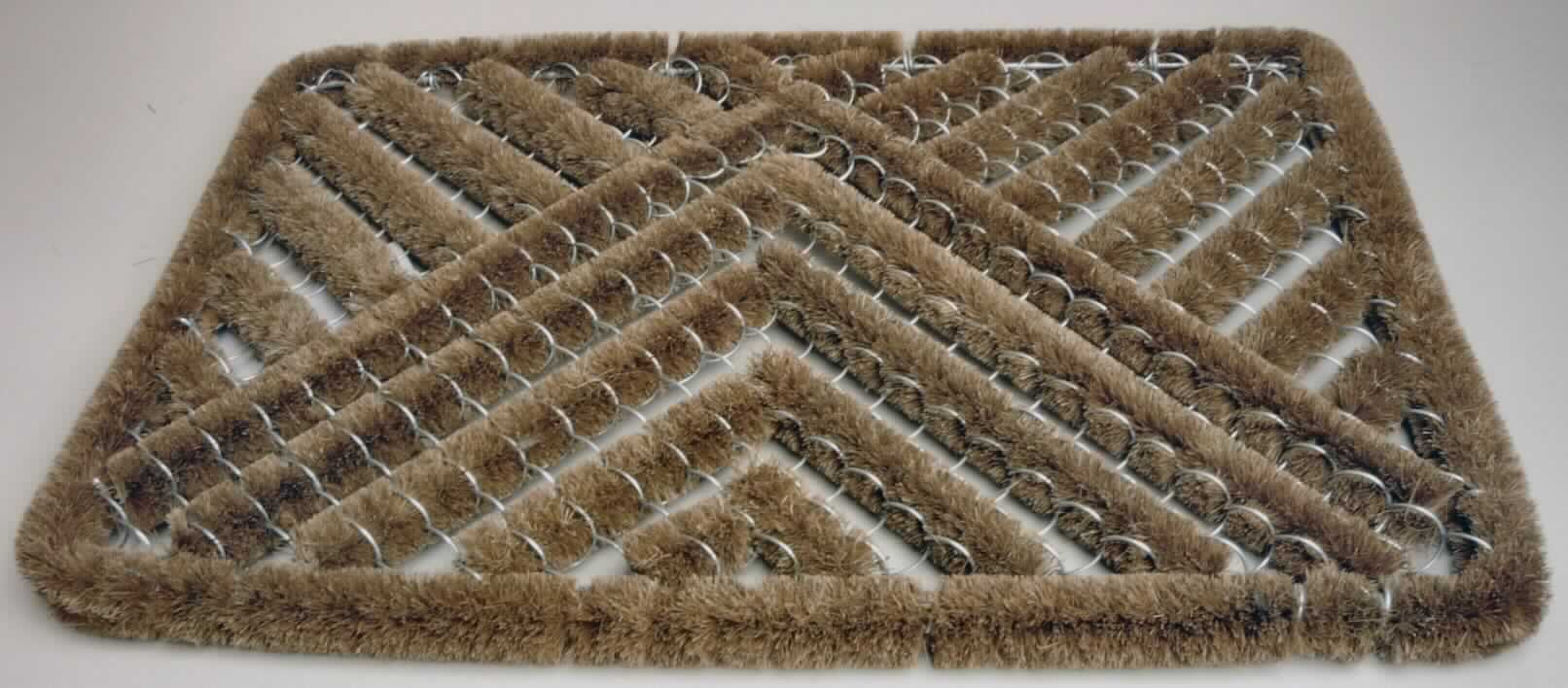 Fußbodenbelag, sog. Drahtgittermatte aus Kokosfasern, Order-Nummer 159507, Foto siehe Anlage,
- rechteckig; in den Abmessungen: etwa 41 cm x 59 cm; mit einer Dicke von etwa 3 cm,
- kein geknüpfter Teppich,
- laut Untersuchungsergebnis: 
-- bestehend aus Kokosfasern (pflanzlicher Spinnstoff) und Metalldrähten (laut Antrag aus einer Legierung
   aus unedlen Metallen); die Kokosfasern sind in ein dreidimensionales Metalldrahtgitter eingebunden,
-- nicht im Webprozess hergestellt, somit kein gewebter Fußbodenbelag der Position 5702,
-- nicht in Nadelflor-Technik hergestellt, somit kein getufteter Fußbodenbelag der Position 5703,
-- nicht aus Filz, somit kein Fußbodenbelag der Position 5704,
- durch Zusammenfügen konfektioniert,
- ohne Hinweise auf Handarbeit,
- bei der Verwendung der Ware als Fußabtreter wird die Schauseite überwiegend durch die Kokosfasern gebildet,
- im Hinblick
-- auf den Wert sind laut Antrag die Metalldrähte gegenüber den Kokosfasern vorherrschend,
-- auf die Verwendung sowie auf das äußere Erscheinungsbild sind die Kokosfasern vorherrschend, sie verleihen
   somit der Ware ihren wesentlichen Charakter.

"Fußbodenbelag, anderer als in den Positionen 5701 bis 5704 genannte, aus Spinnstoffen, konfektioniert,
 aus  Kokosfasern, nicht handgearbeitet"