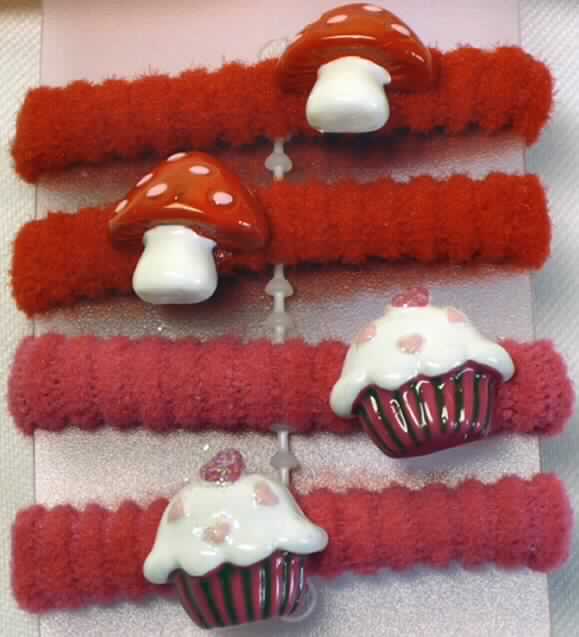 Bekleidungszubehör (Haargummis), Foto siehe Anlage,
- als vierteiliges Sortiment auf einer Kunststoffkarte aufgemacht,
- jeweils bestehend aus einem gummielastischen (laut Antrag 5% Rubber), aufgerollten, schlauchförmigen
  Schlingengewirke aus Spinnstoffen mit einem Durchmesser von etwa 2 cm,
- zwei Haargummis mit einem angeklebten "Pilz" und zwei Haargummis mit einem angeklebten "Muffin"
  aus Kunststoff,
- durch Zusammenfügen konfektioniert,
- dient zum Zusammenhalten des Haares und zugleich als Kopfschmuck,
- im Hinblick auf die Verwendung bestimmt das Gewirke den Charakter der Ware.

"Anderes konfektioniertes Bekleidungszubehör (Haargummis), aus gummielastischen Gewirken"
