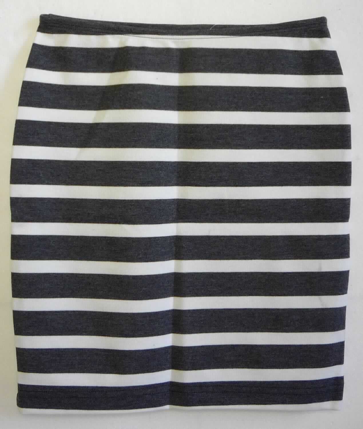 Rock, sog. Strick Minirock, Art. RSAPO323S, Größe S, Foto siehe Anlage,
- aus ca. 0,8 mm dicken, buntgewirkten Gewirken (melierte Garne) aus laut Antrag 65 % Polyester, 5 % Elasthan 
  (beides synthetische Chemiefasern) und 30 % Viskose (künstliche Chemiefasern),
- über den Schritt reichend (Seitenlänge: ca. 39 cm),
- in der Taille abschließend; mit einem ca. 1 cm breiten, elastischen Taillenbund,
- ohne Öffnung und ohne Verschluss,
- am unteren Rand durch Umschlagen und Festnähen gesäumt,
- kann ohne ein weiteres, den Unterkörper bedeckendes Kleidungsstück getragen werden.

"Rock aus Gewirken, für Frauen, aus synthetischen Chemiefasern"