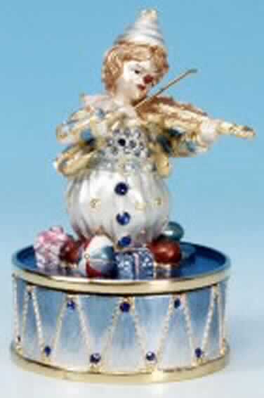 Sog. Spieluhr "Geigenclown", Art.Nr. 25039, siehe Foto.
Es handelt sich um eine Spieldose aus emailliertem Metall, die einen Geige spielenden Clown darstellt, der auf 
einer Trommel sitzt (Höhe: 85mm). Nach dem Aufziehen des Mechanismus dreht sich der Clown zur
Melodie "Music of the night". 

Diese Ware ist als "Spieldose" einzureihen.